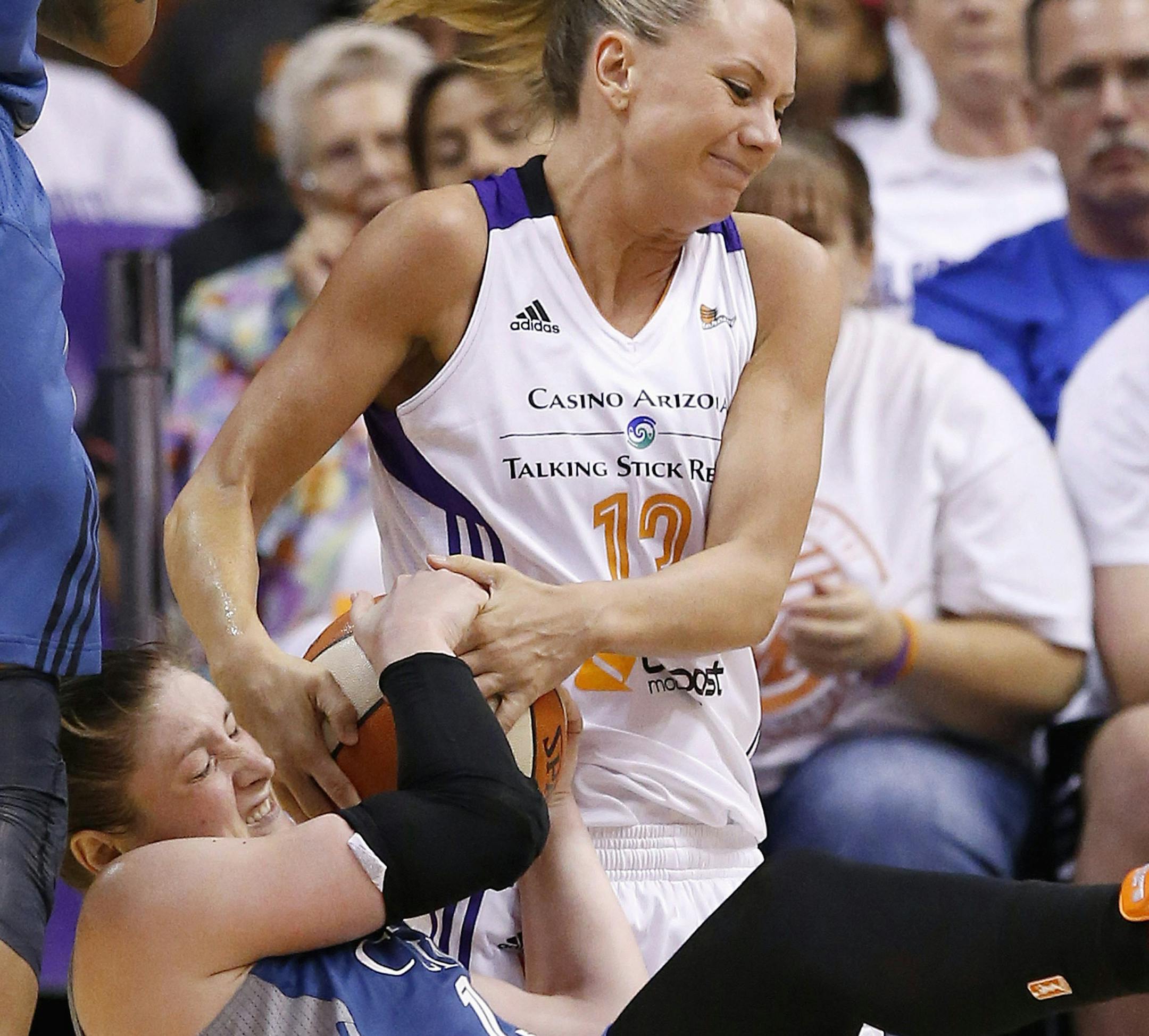 Minnesota Lynx's Lindsay Whalen, bottom, battles Phoenix Mercury's Penny Taylor, of Australia, for a loose ball during the second half in Game 1 of the WNBA Western Conference finals Friday, Aug. 29, 2014, in Phoenix. The Mercury defeated the Lynx 85-71. (AP Photo/Ross D. Franklin)