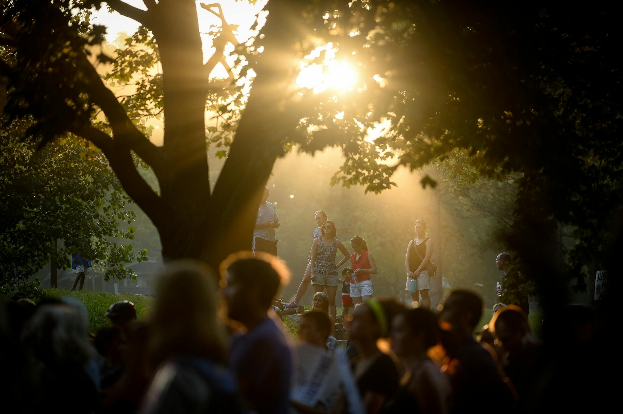The sun set behind demonstrators at Beard's Plaissance Park Thursday night.