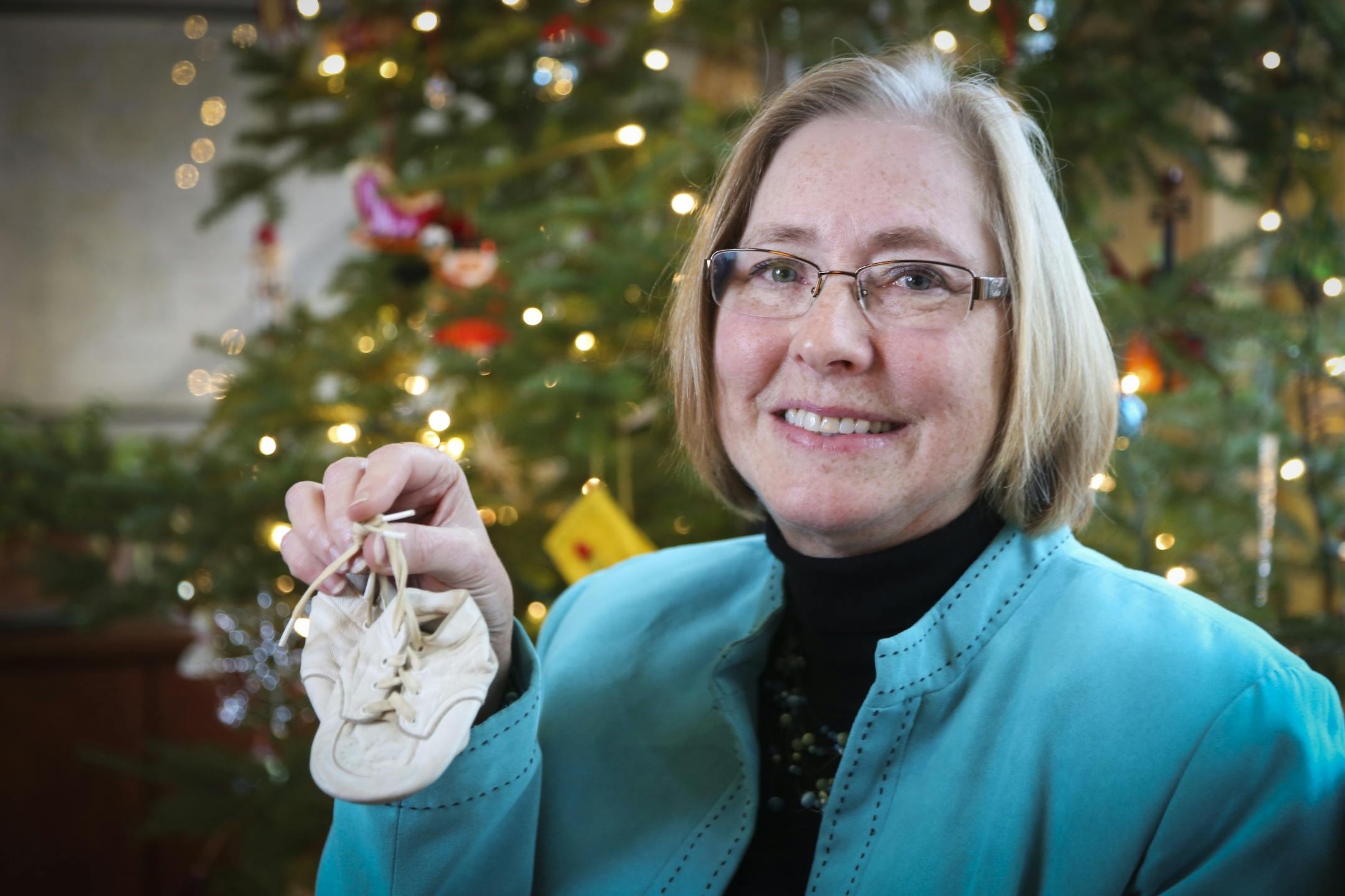 Deborah Jindra with her baby shoes. Her mother found them in her father's toolbox after he died.