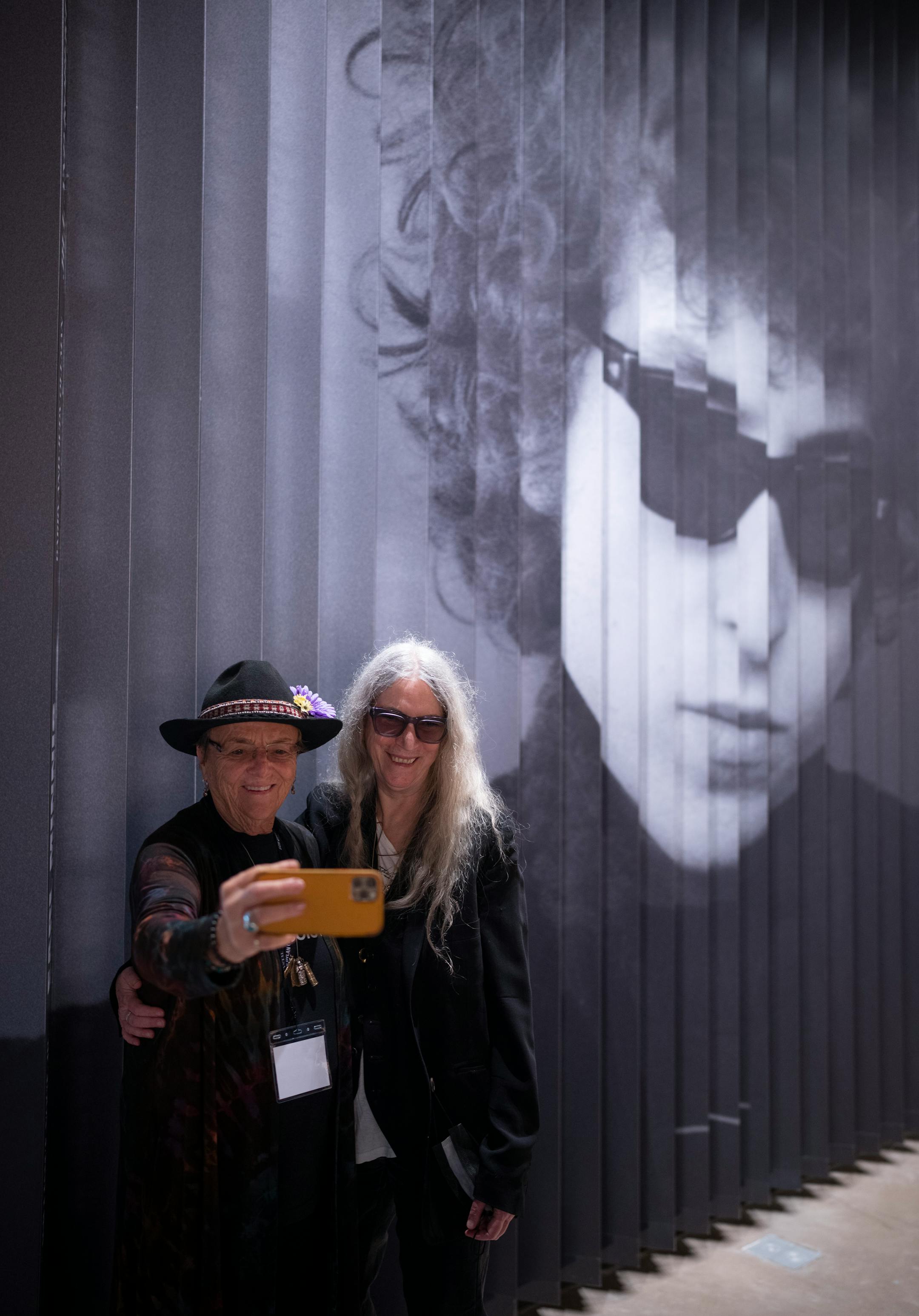 Lisa Law held Patti Smith's iPhone to take a selfie of the two of them in front of a giant blow up of Law's 1966 photograph of Bob Dylan in the lobby of the Bob Dylan Center in Tulsa, Okla. on Friday, May 6, 2022.