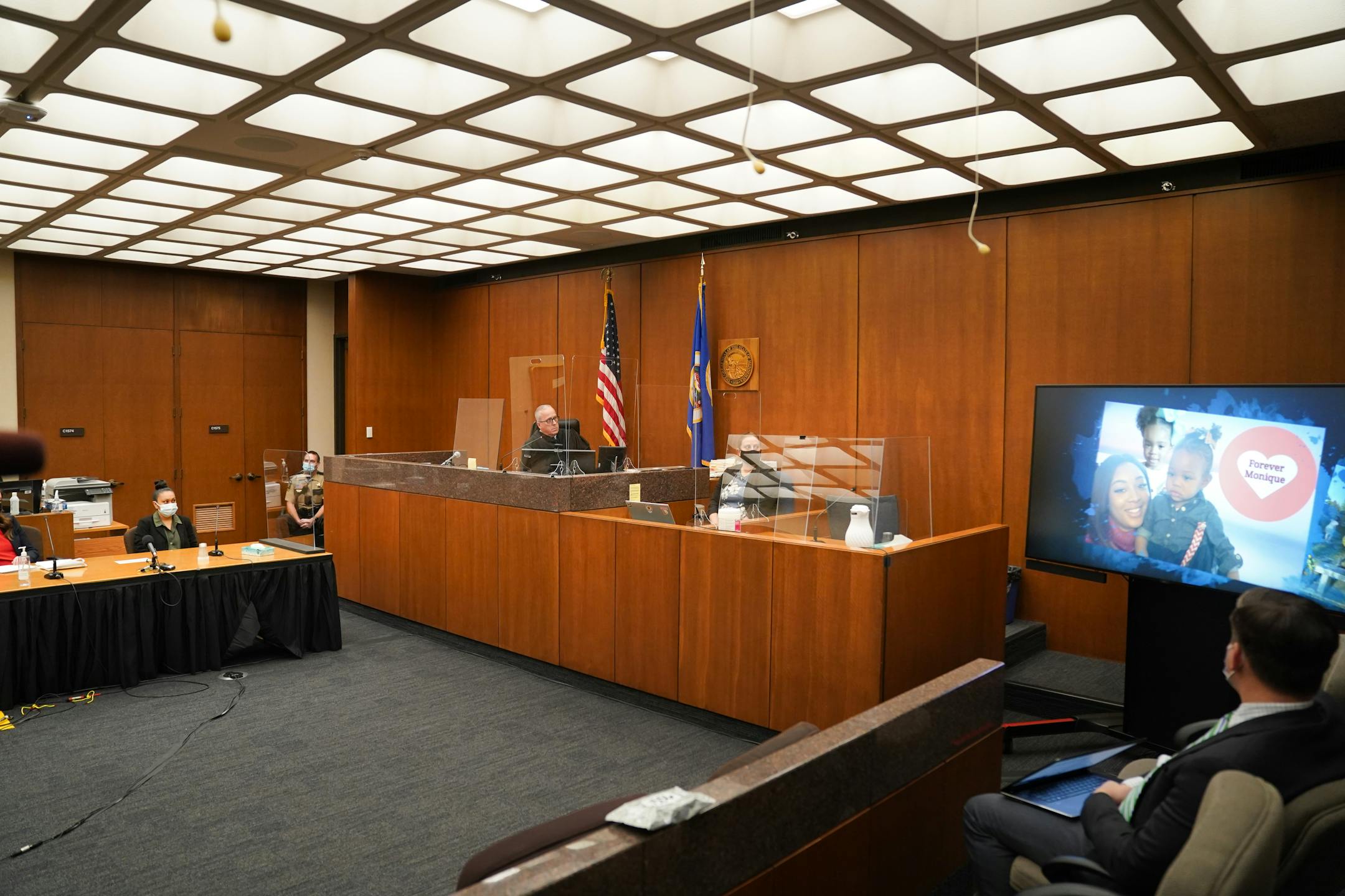 Elsa Segura, left, Judge Peter Cahil, center, watched a video tribute to Monique Baugh, prpr to sentencing. Former Hennepin County probation officer, Elsa Segura, is sentenced, Tuesday, Nov. 9, 2021, in Hennepin County Court, Minneapolis, Minn., for luring Realtor, Monique Baugh, to a fake home showing where she was kidnapped and murdered.