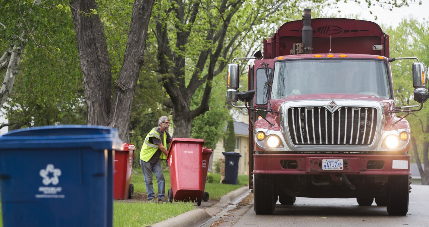 Patrick Cunningham with Burt&#x2019;s Disposal emptied a garbage container into his truck in Bloomington. The city may switch from seven haulers to one.