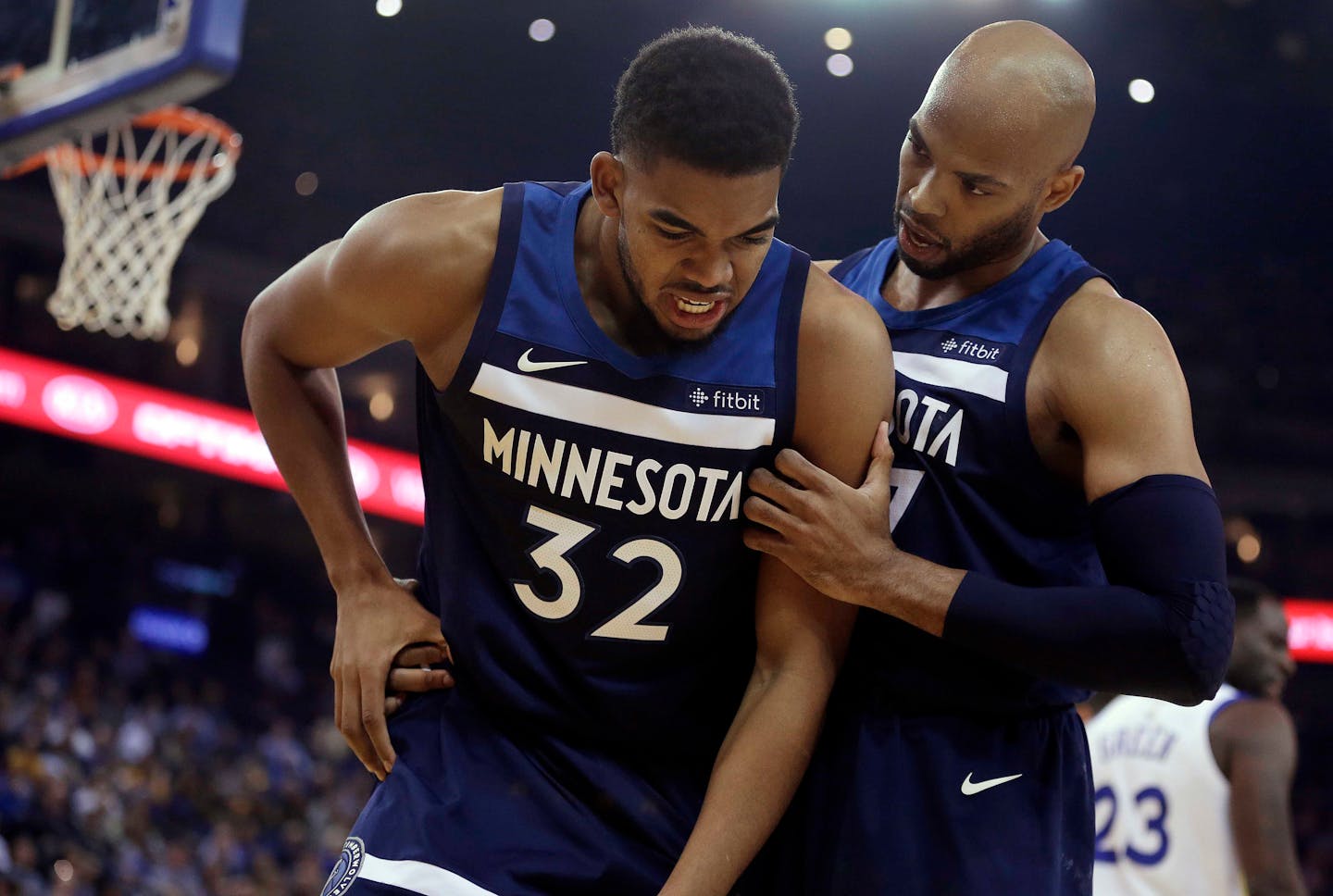 Minnesota Timberwolves' Taj Gibson, right, checks on the condition of Karl-Anthony Towns (32), who had collided with Golden State Warriors' Draymond Green during the first half of an NBA basketball game Wednesday, Nov. 8, 2017, in Oakland, Calif. (AP Photo/Ben Margot)