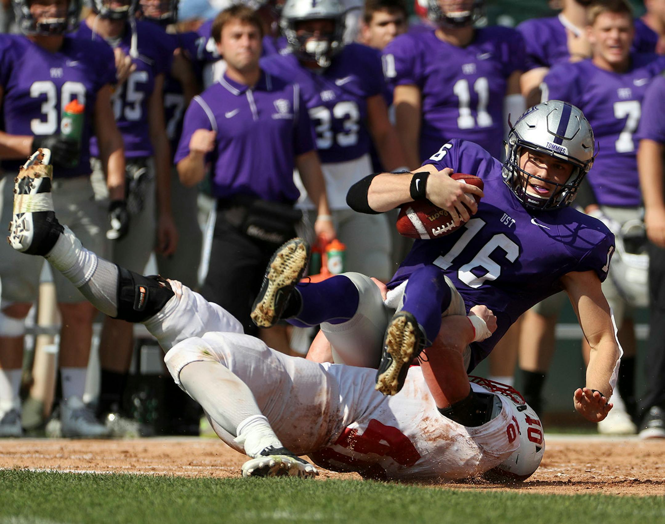 University of St. Thomas quarterback Jacques Perra (16) was sacked by St. John's University defensive lineman Drew Glenzinski (40) in the first half.