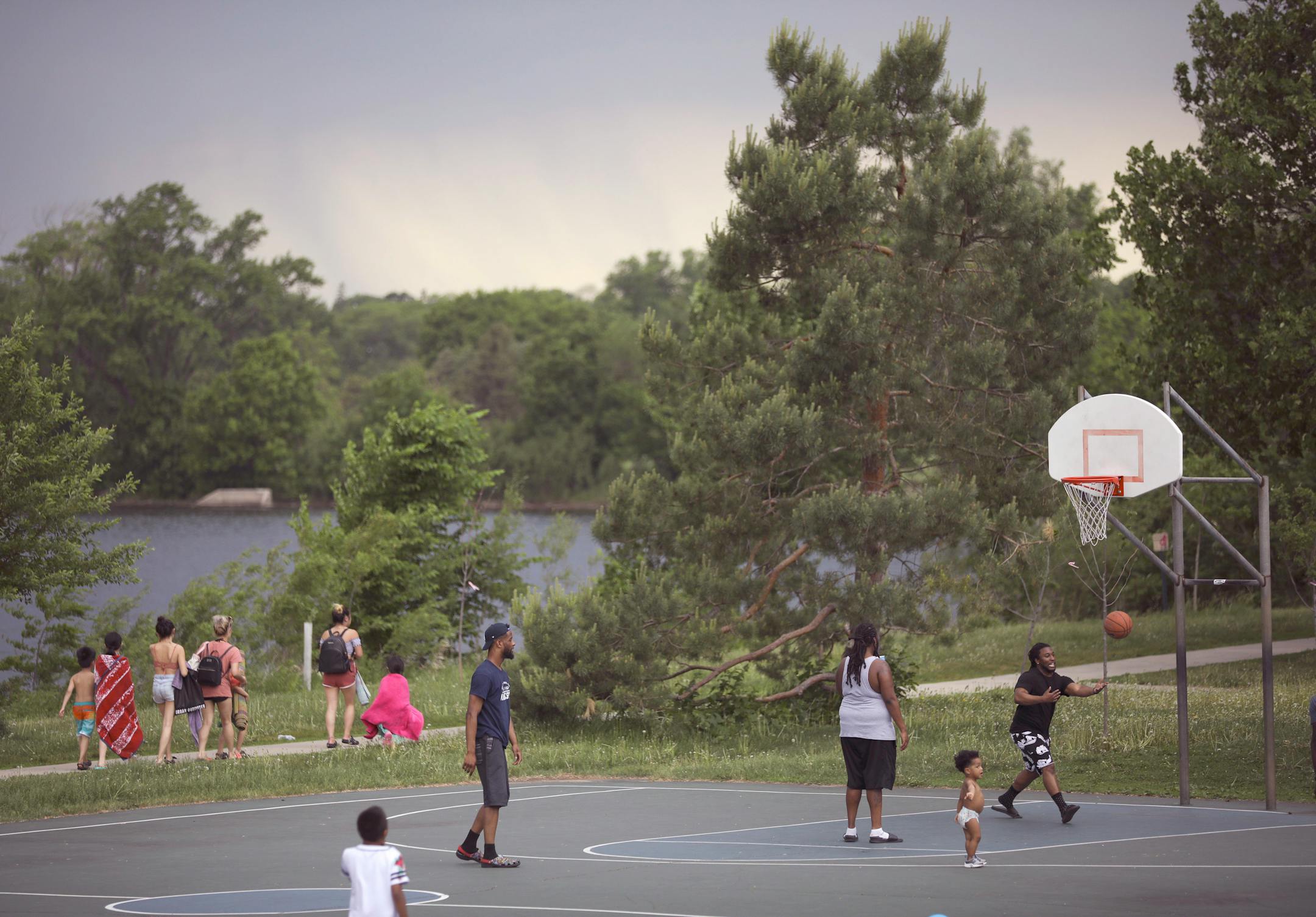 With rain in the distance, some friends played basketball while they attended a Memorial Day cookout at Lake Hiawatha Park in Minneapolis Monday afternoon. They are, from left, Mike Rose, Von Gibson, Justice Rose (the toddler), and Jarret Westbrook.
