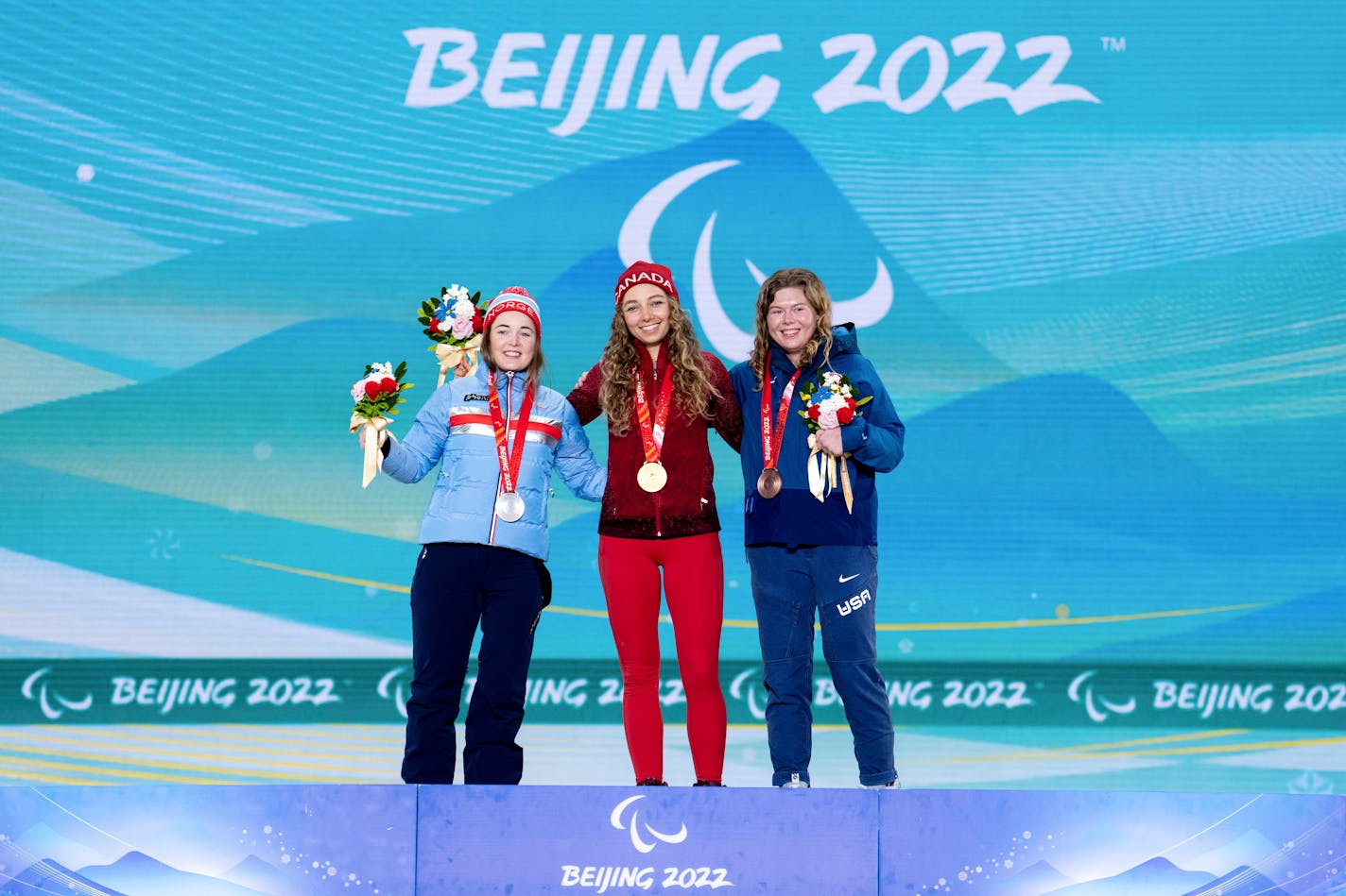 Gold medalist Natalie Wilkie, of Canada, center, poses with silver medalist Vilde Nilsen, of Norway, left, and bronze medalist Sydney Peterson, of Lake Elmo for the Women's Sprint Free Technique Standing Para Cross-Country Skiing