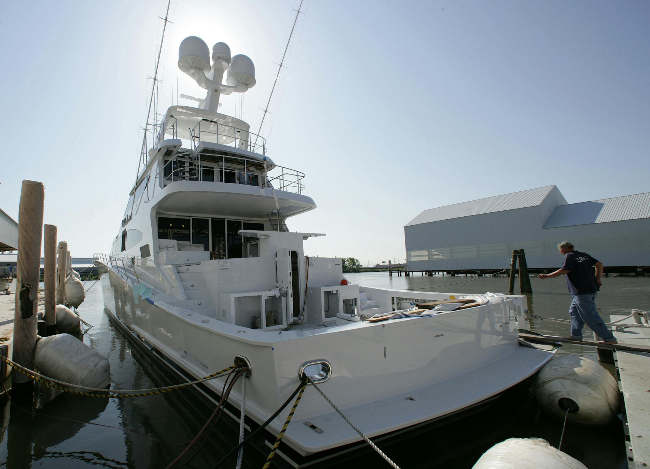 A worker climbs aboard a super yacht at Trinity Boats in New Orleans.