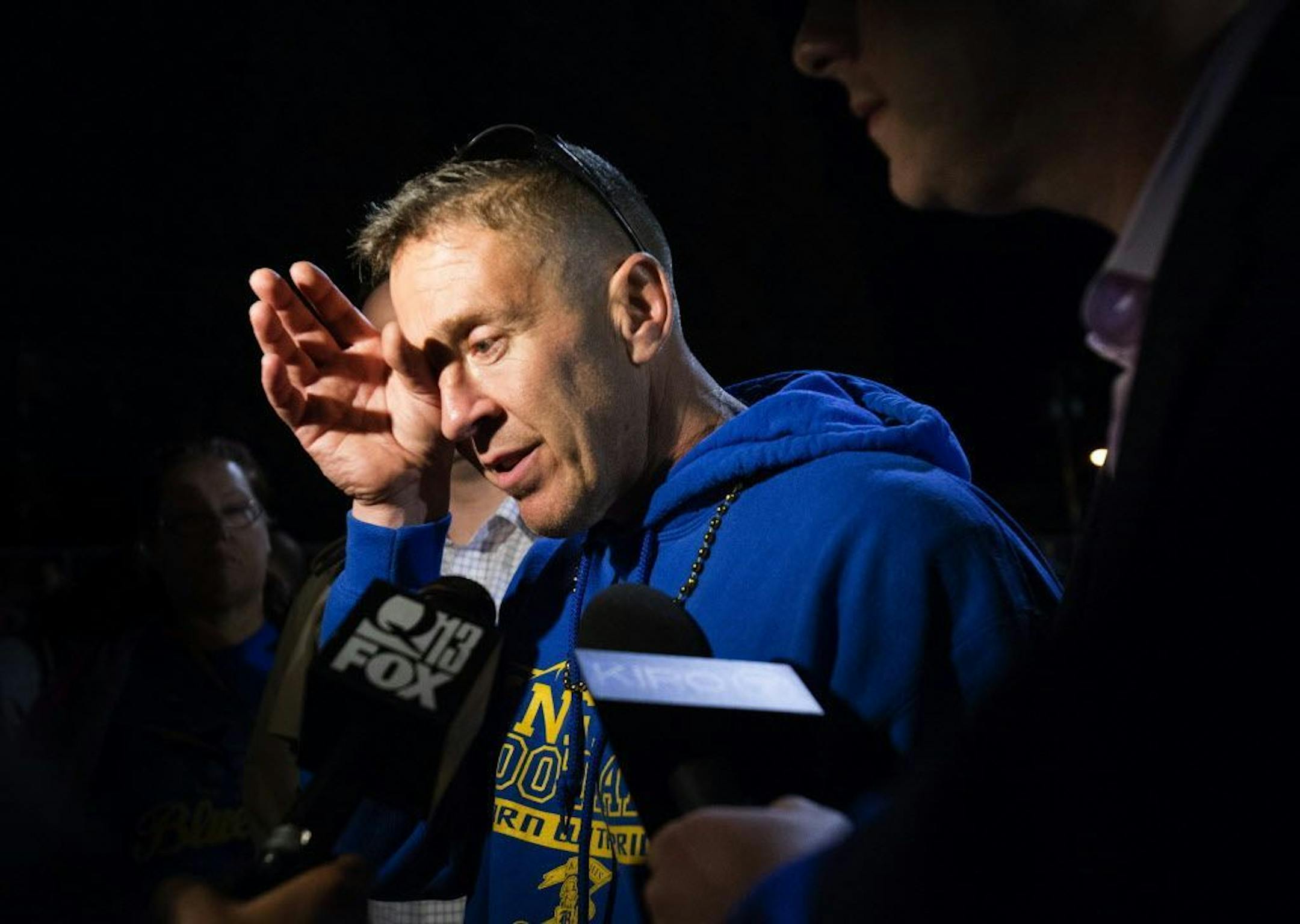 FILE - In this Friday, Oct. 16, 2015, file photo, Bremerton High assistant football coach Joe Kennedy wipes his eyes as he talks to the media after a football game in Bremerton, Wash. The coach of a Washington state high school football team who prayed at games despite orders from the school district to stop has been placed on paid administrative. Bremerton School District officials said in a statement late Wednesday, Oct. 28, 2015, that assistant football coach Joe Kennedy's leave was necessita