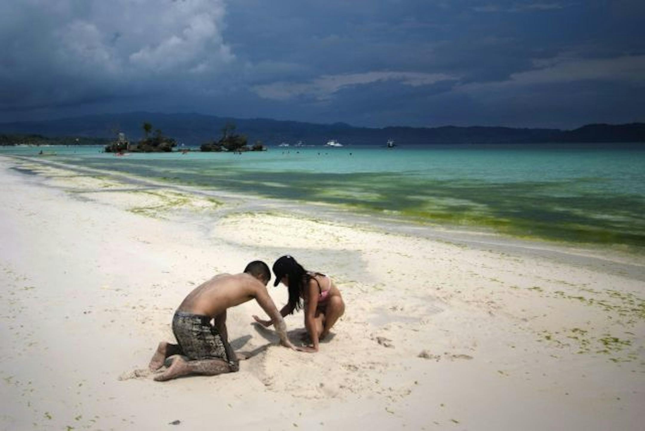 Visitors make a sand castle on the beach of Boracay Island, Philippines.