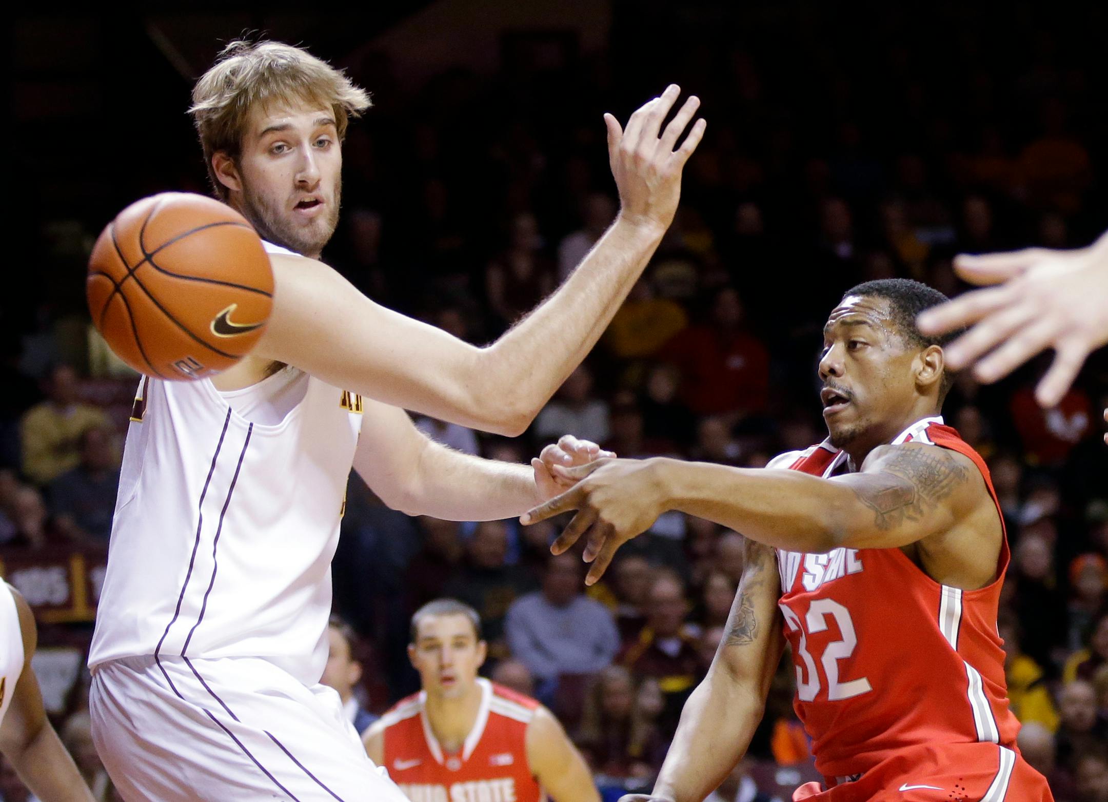 Ohio State's Lenzelle Smith Jr., right, gets a pass around Minnesota's Elliott Eliason in the first half of an NCAA college basketball game, Thursday, Jan. 16, 2014, in Minneapolis. (AP Photo/Jim Mone)