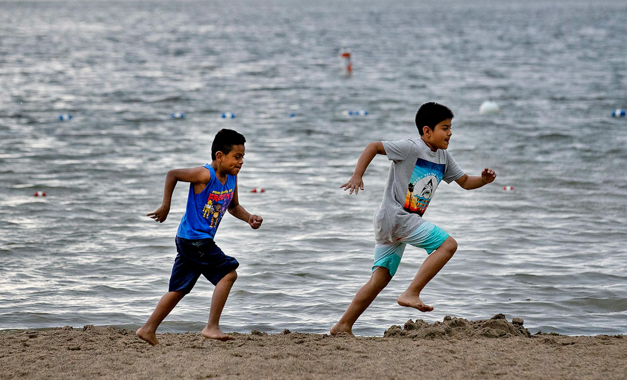 Alex Cardoso, 8, of Fridley and Adrian Hilguera, 11, of Hopkins raced along the shore at Bryant Lake Regional Park in Eden Prairie.