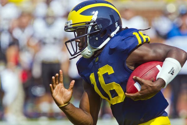 FILE - In this Sept. 3, 2011, file photo, Michigan quarterback Denard Robinson (16) rushes with the ball in the first quarter of an NCAA college footb