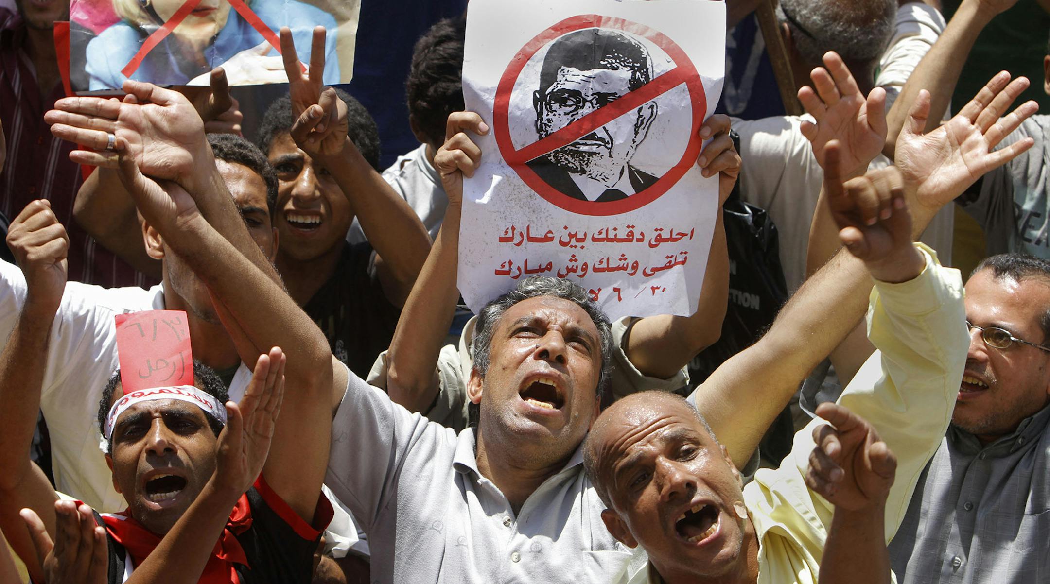 Egyptian protesters shout anti-Muslim Brotherhood slogans as they hold posters depicting U.S. Ambassador to Egypt Anne Patterson and President Mohammed Morsi during a protest in Tahrir Square, the focal point of Egyptian uprising, in Cairo, Egypt, Friday, June 28, 2013. Arabic on the poster at center reads, "shave your beard show your shame, you will look like Mubarak." Egypt's opposition plans to bring out massive crowds on Sunday in protests nationwide, vowing to force President Mohammed Morsi