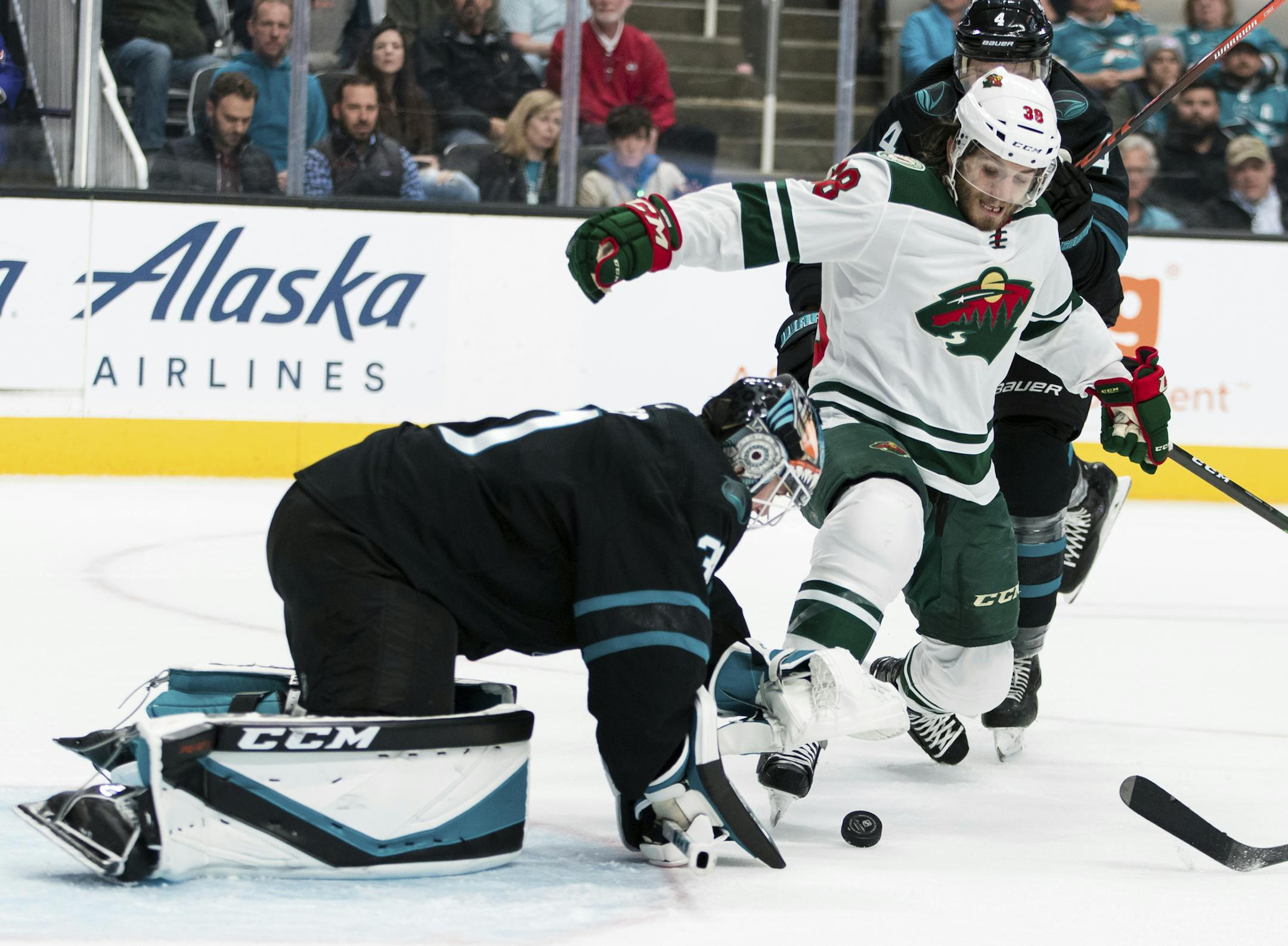 San Jose Sharks goaltender Martin Jones, left, and Minnesota Wild right wing Ryan Hartman (38) scramble for the puck during the second period of an NHL hockey game Thursday, Nov. 7, 2019, in San Jose, Calif. (AP Photo/John Hefti)