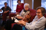 Ruth Fingerson demonstrated a time-travel concept with a piece of paper during discussion of "A Wrinkle in Time" at Summit Place in Eden Prairie.