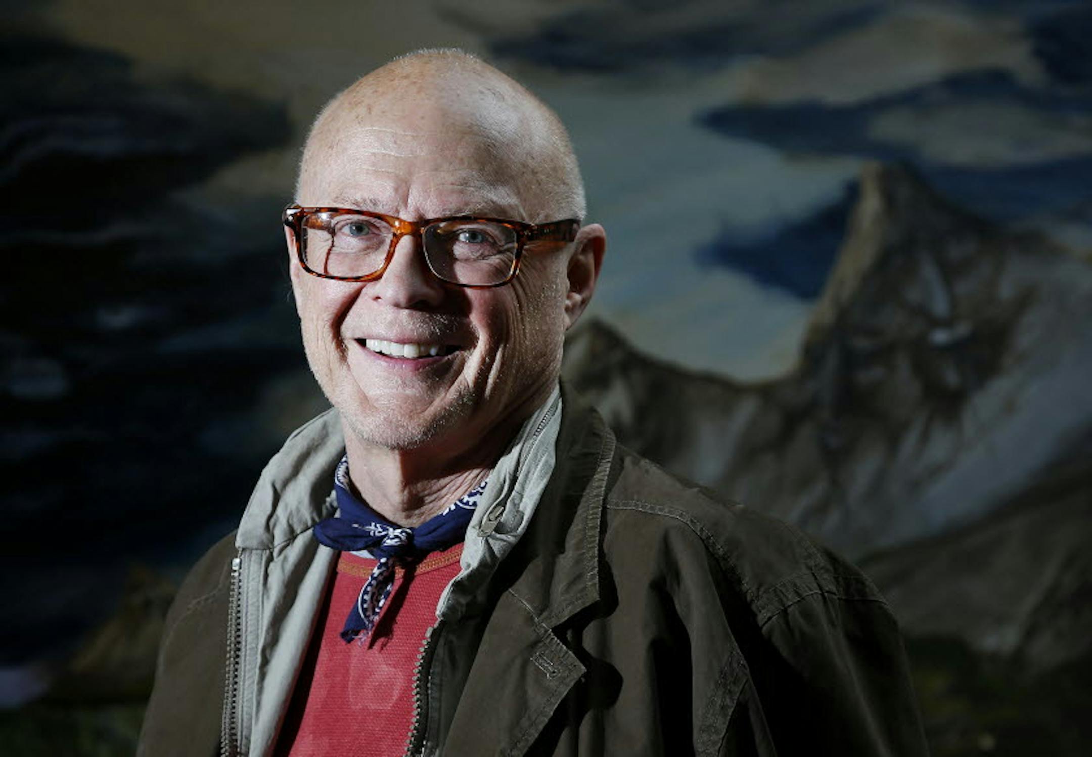 Bob Calton posed in front of a mural he painted, and pointed out a detail in a stained-glass window.
