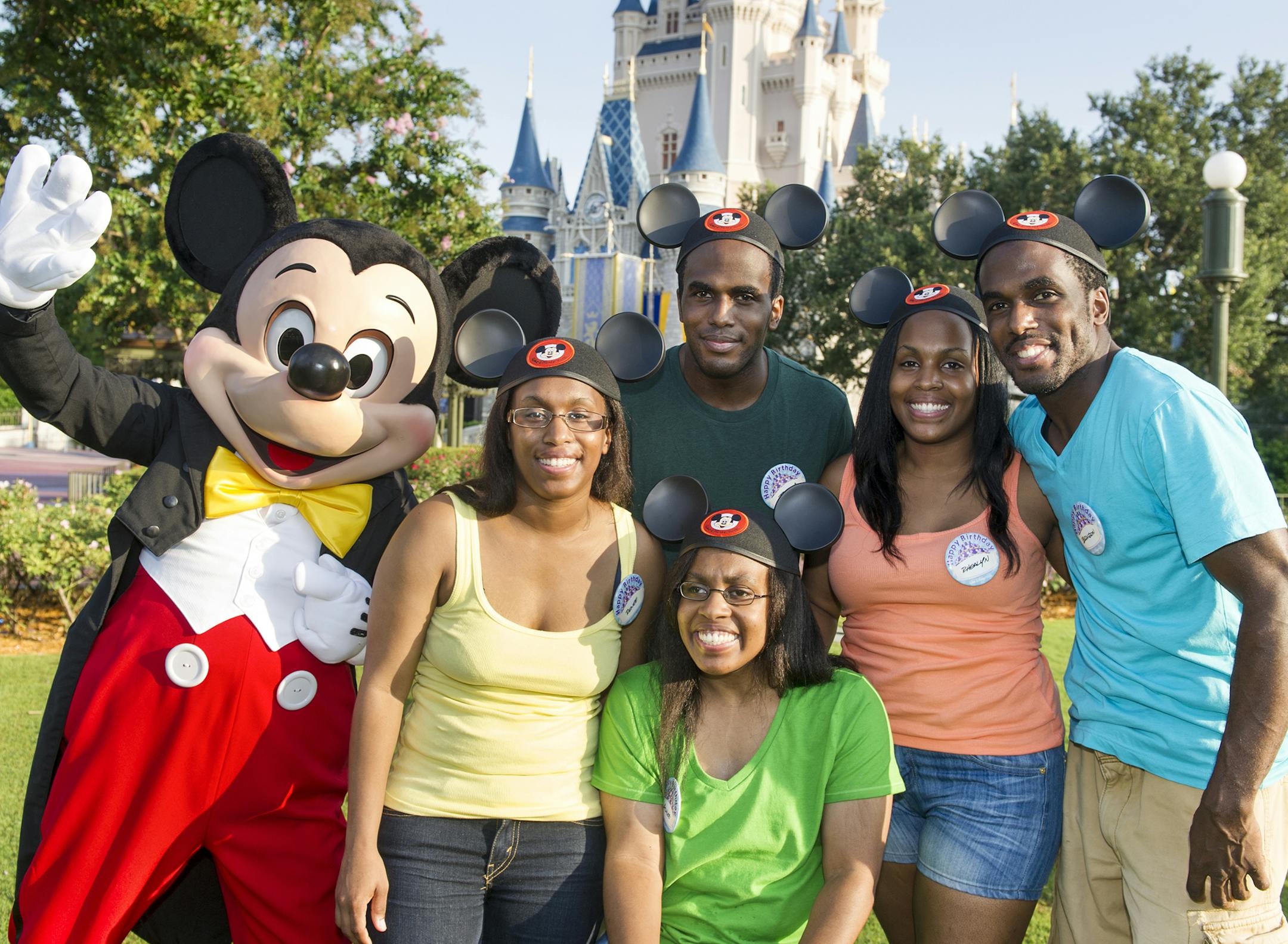 This Aug. 5, 2013 photo released by Disney shows Mickey Mouse posing with the Gaither quintuplets, standing from left, Renee Gaither-Williams, Joshua Gaither, Rhealyn Gaither-Thomas, Brandon Gaither and Ashlee Gaither, seated, outside the Magic Kingdom at Walt Disney World in Lake Buena Vista, Fla. The five siblings, from Indianapolis, Ind., celebrated their 30th birthday at the theme park. Born Aug. 3, 1983, they last visited Walt Disney World as a family to celebrate their 10th birthdays. (AP