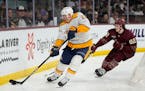 Predators defenseman Tyson Barrie (22) skates away from Coyotes center and former Gophers star Logan Cooley during the third period, but Cooley scored