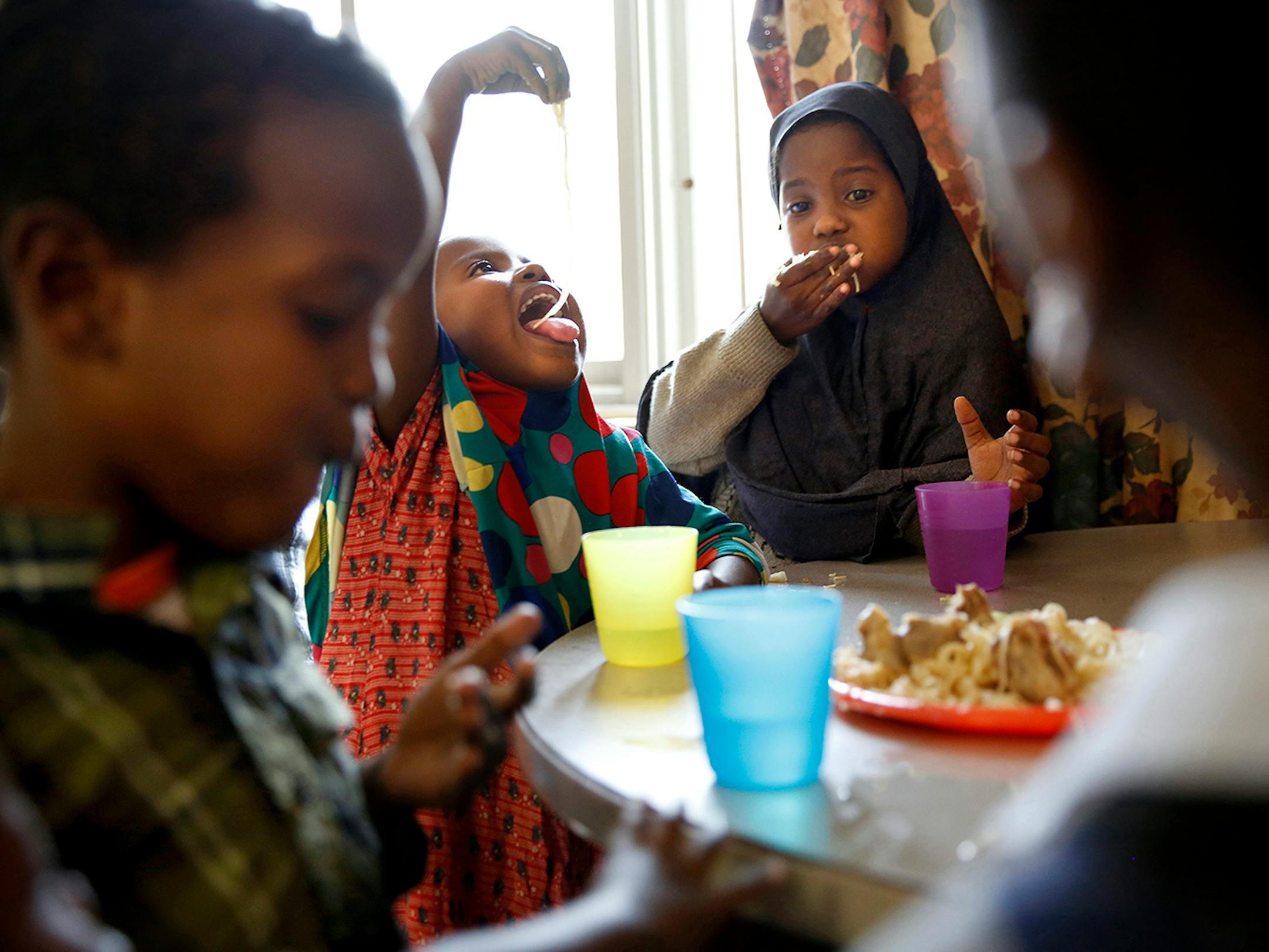 Recent Somali immigrants Hafifa Shukri, left, 4, and her sister Ugbad Shukri, 9, enjoy an afternoon snack of pasta with goat meat at home at Mary's Place transitional apartments in downtown Minneapolis. ] LEILA NAVIDI leila.navidi@startribune.com / BACKGROUND INFORMATION: Tuesday, October 28, 2014. Minnesota has seen a marked uptick in new Somali refugee arrivals recently. The number of Somalis arriving directly from Africa has more than tripled in four years. But community leaders say there's a