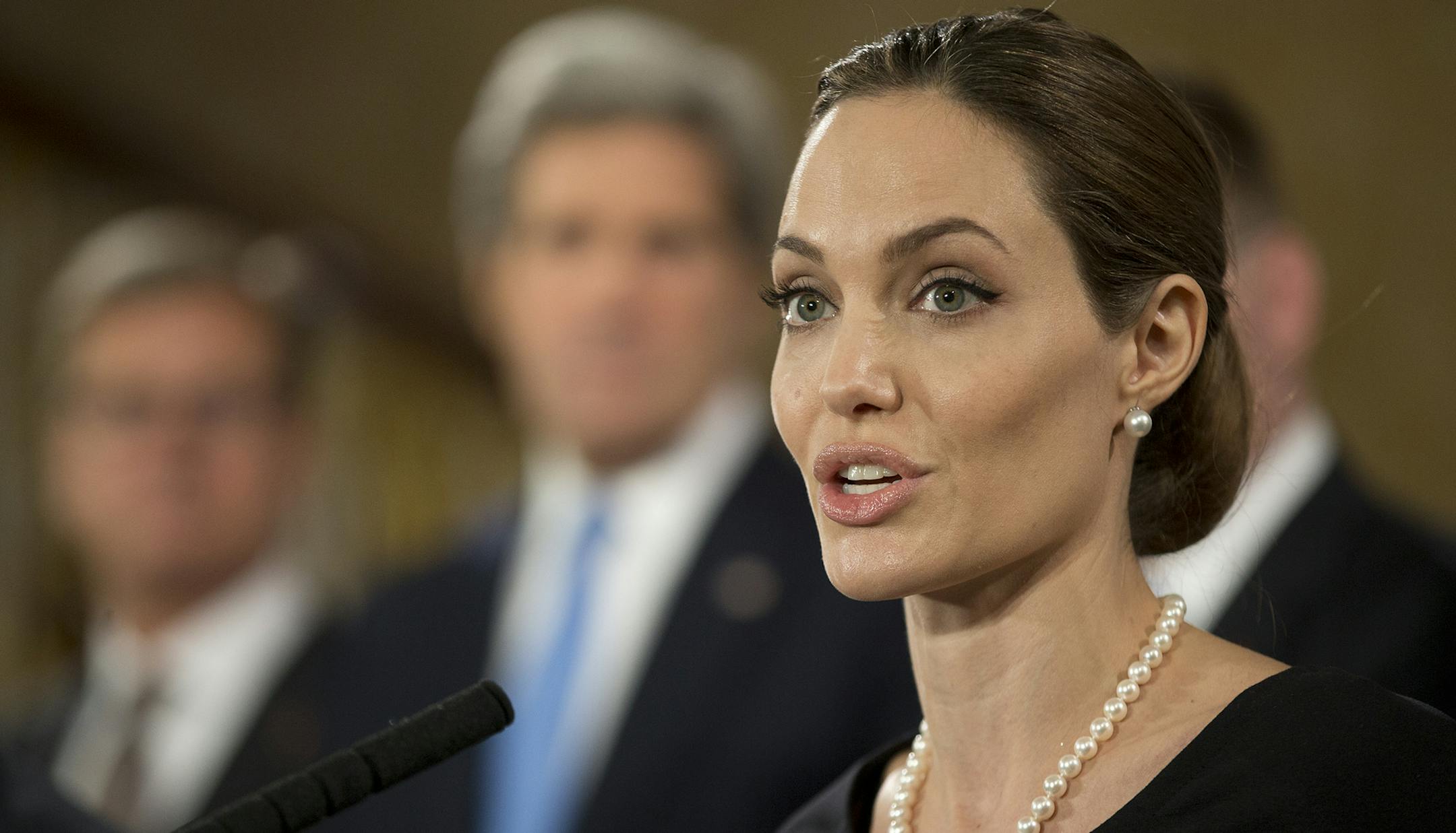 Flanked by G8 Foreign Ministers, US actress Angelina Jolie, in her role as UN envoy, talks during a news conference regarding sexual violence against women in conflict, during the G8 Foreign Ministers meeting in London, Thursday, April, 11, 2013. The ministers are meeting in London as Britain currently holds the G8 Presidency, with the heads of government G8 meeting set for June in Northern Ireland.(AP Photo/Alastair Grant, pool)