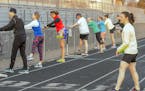 Nicole Cueno, right, coaches athletes during track workout.