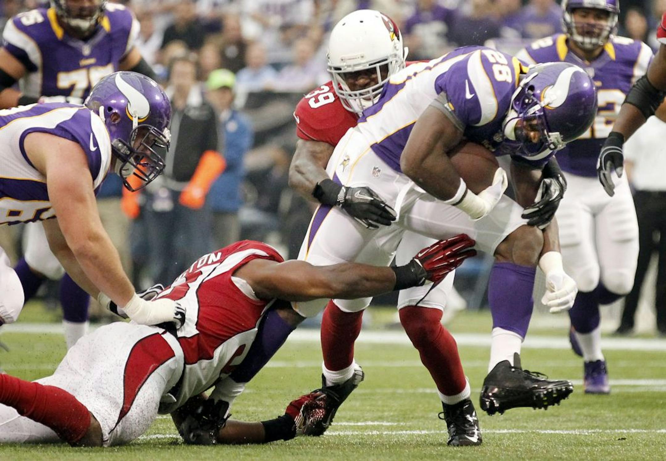 Minnesota Vikings running back Adrian Peterson (28) ran through Cardinals defenders on his way to score a touchdown in the first quarter.