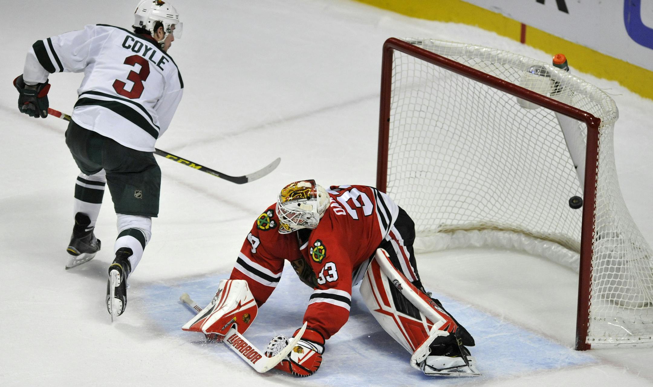 Minnesota Wild's Charlie Coyle (3) scores a goal against Chicago Blackhawks goalie Scott Darling (33) during a shootout in an NHL hockey game Sunday, March 20, 2016, in Chicago. Minnesota won 3-2 in a shootout. (AP Photo/Paul Beaty)