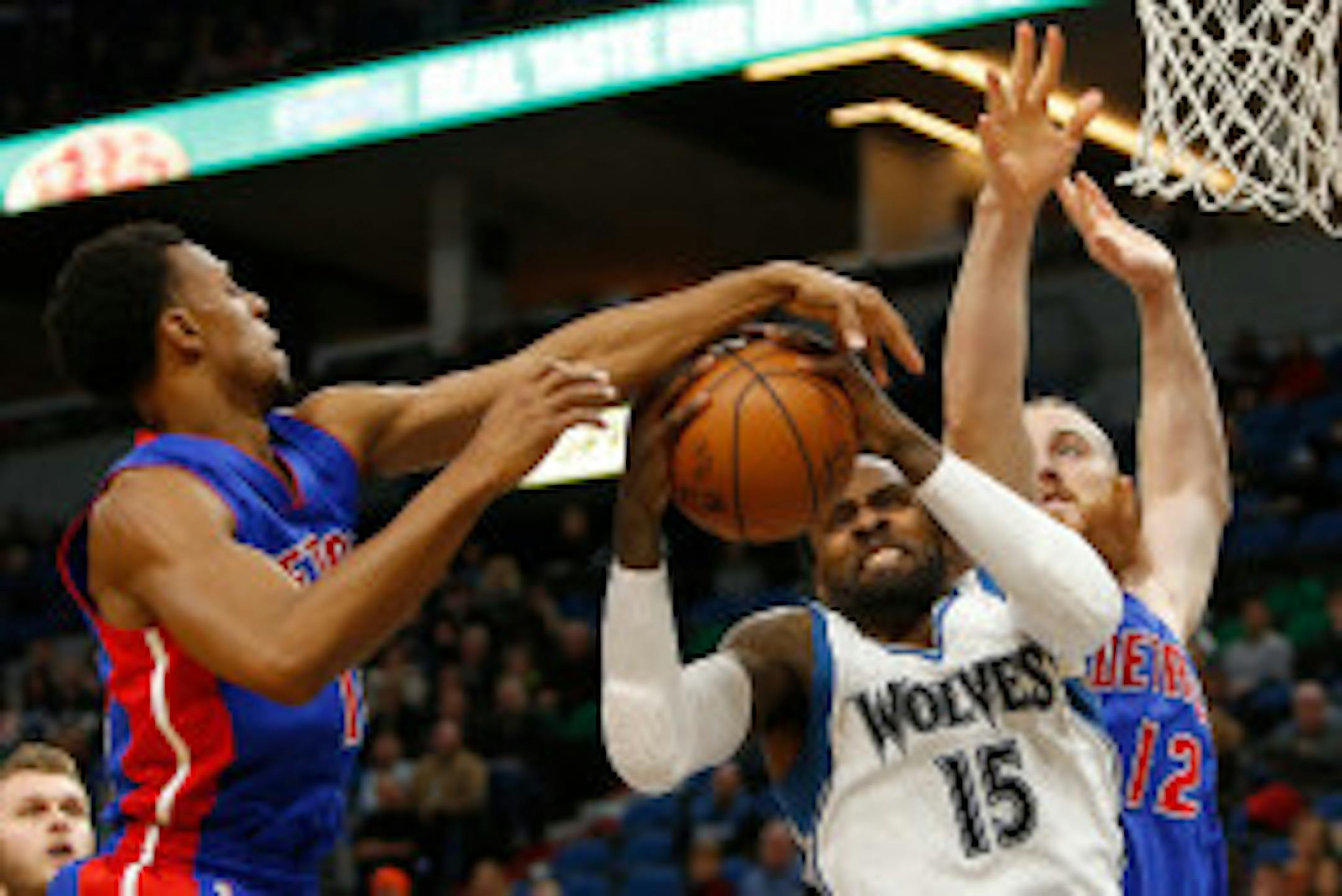 Timberwolves forward Shabazz Muhammad (15) tries to grab a rebound against Detroit Pistons guard Ish Smith (14) and center Aron Baynes (12)