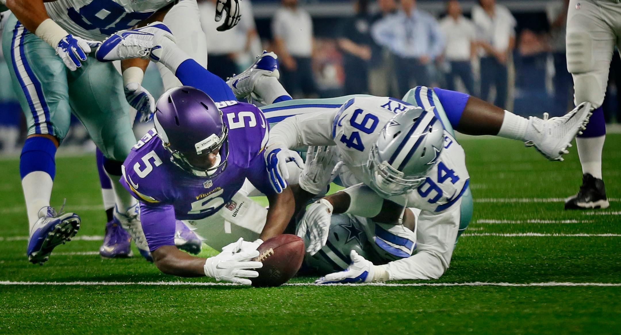 Minnesota Vikings quarterback Teddy Bridgewater (5) recovered his fumble from Dallas Cowboys defensive end Randy Gregory (94) in the first quarter. The Dallas Cowboys played the Minnesota Vikings at AT&T Stadium Saturday August 29 2015 in Arlington, TX.