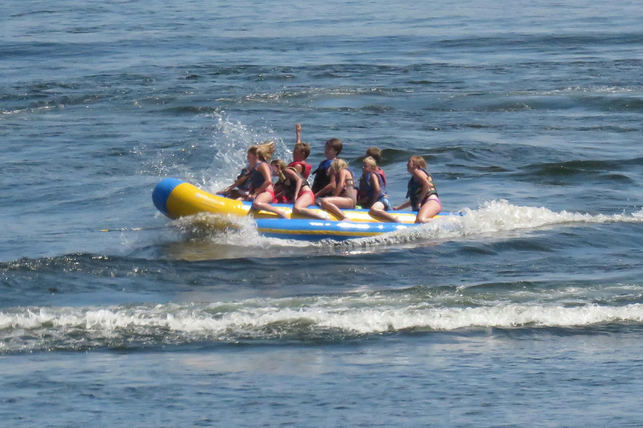 About a dozen kids pile onto Madden's "banana taxi" for the popular shriek-worthy spin around the lake and skip across the waves.