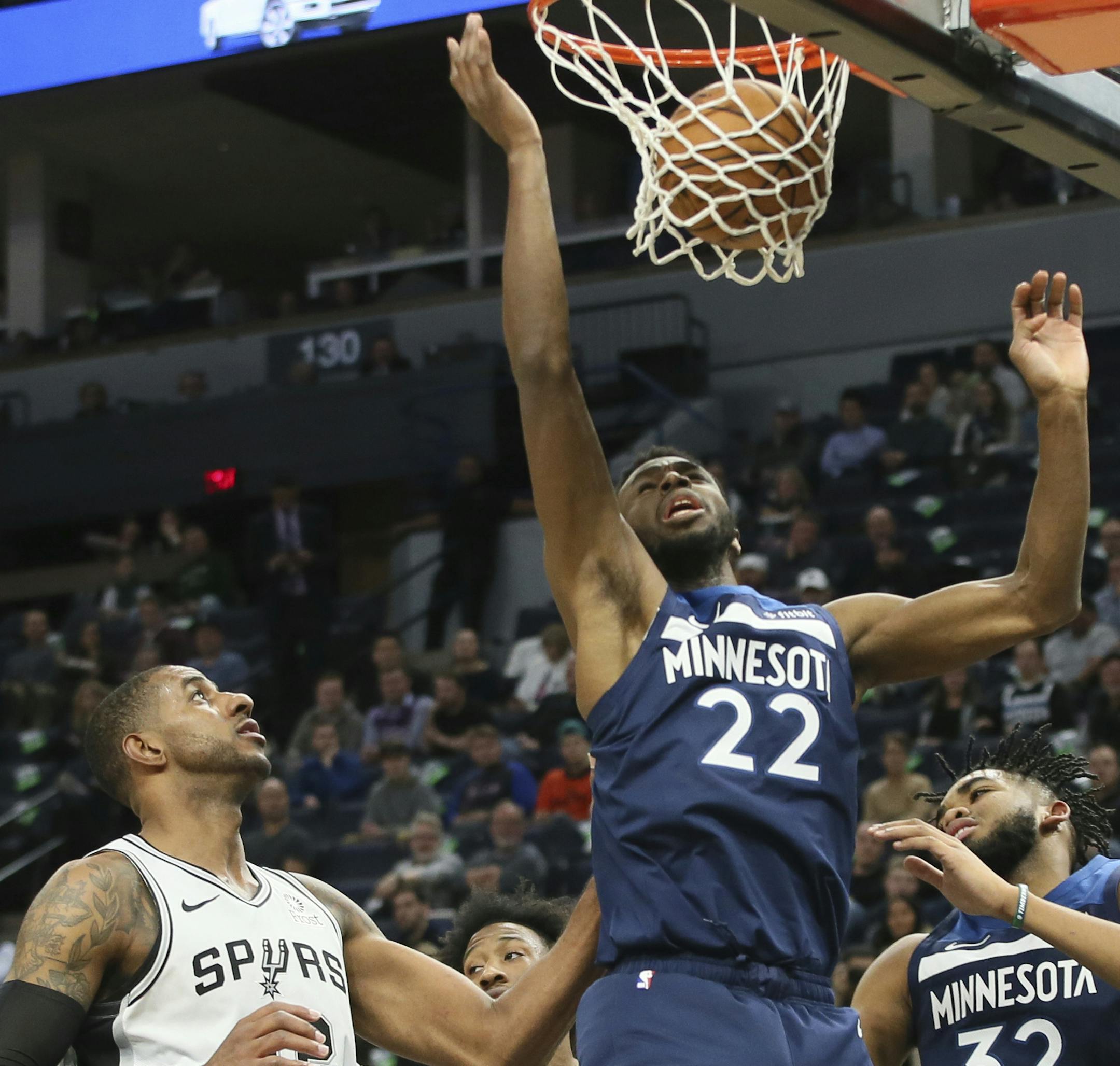 Minnesota Timberwolves' Andrew Wiggins, right, scores a basket as San Antonio Spurs' LaMarcus Aldridge, left, looks on in the second half of an NBA basketball game Wednesday, Nov 13, 2019, in Minneapolis. The Timberwolves won 129-114. (AP Photo/Jim Mone)