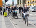 Copenhagen, Denmark - April 28, 2015: People going by bike in the city. A lot of commuters, students and tourists prefer using bike instead of car or 