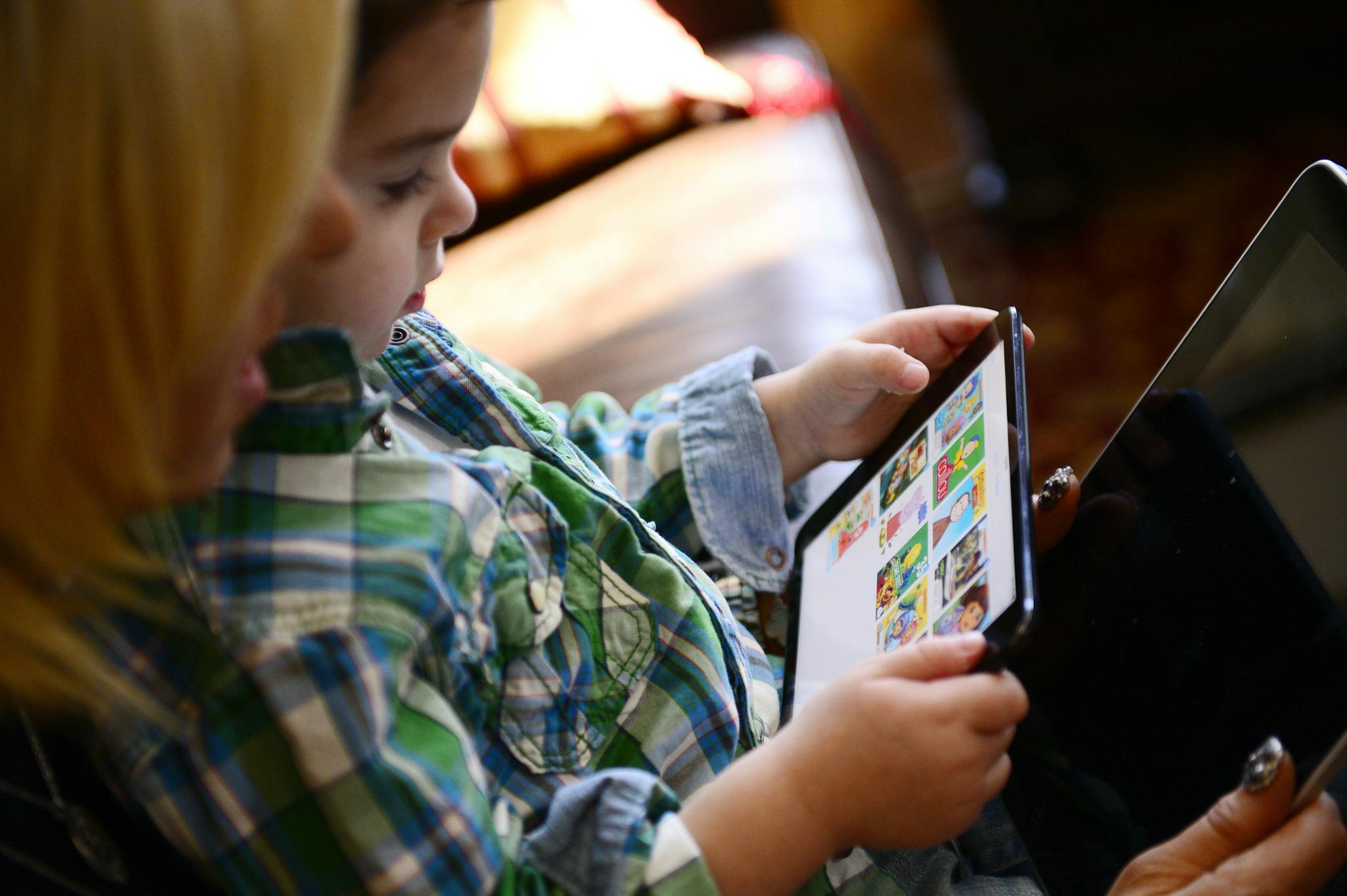 Ben Maddon Segall, 3, plays on an iPad mini as his mother, Elyse, watches, at their home in Livingston, N.J.
