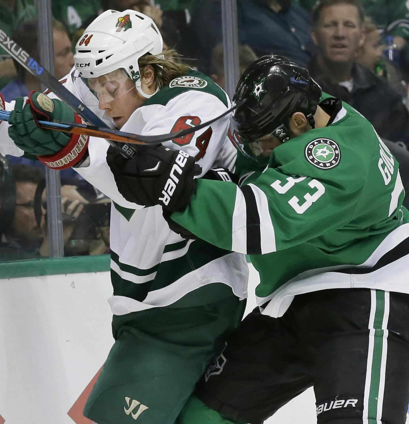 Minnesota Wild center Mikael Granlund (64) and Dallas Stars defenseman Alex Goligoski (33) vie for control of the puck during the second period of Game 1 in a first-round NHL hockey Stanley Cup playoff series Thursday, April 14, 2016, in Dallas. (AP Photo/LM Otero)