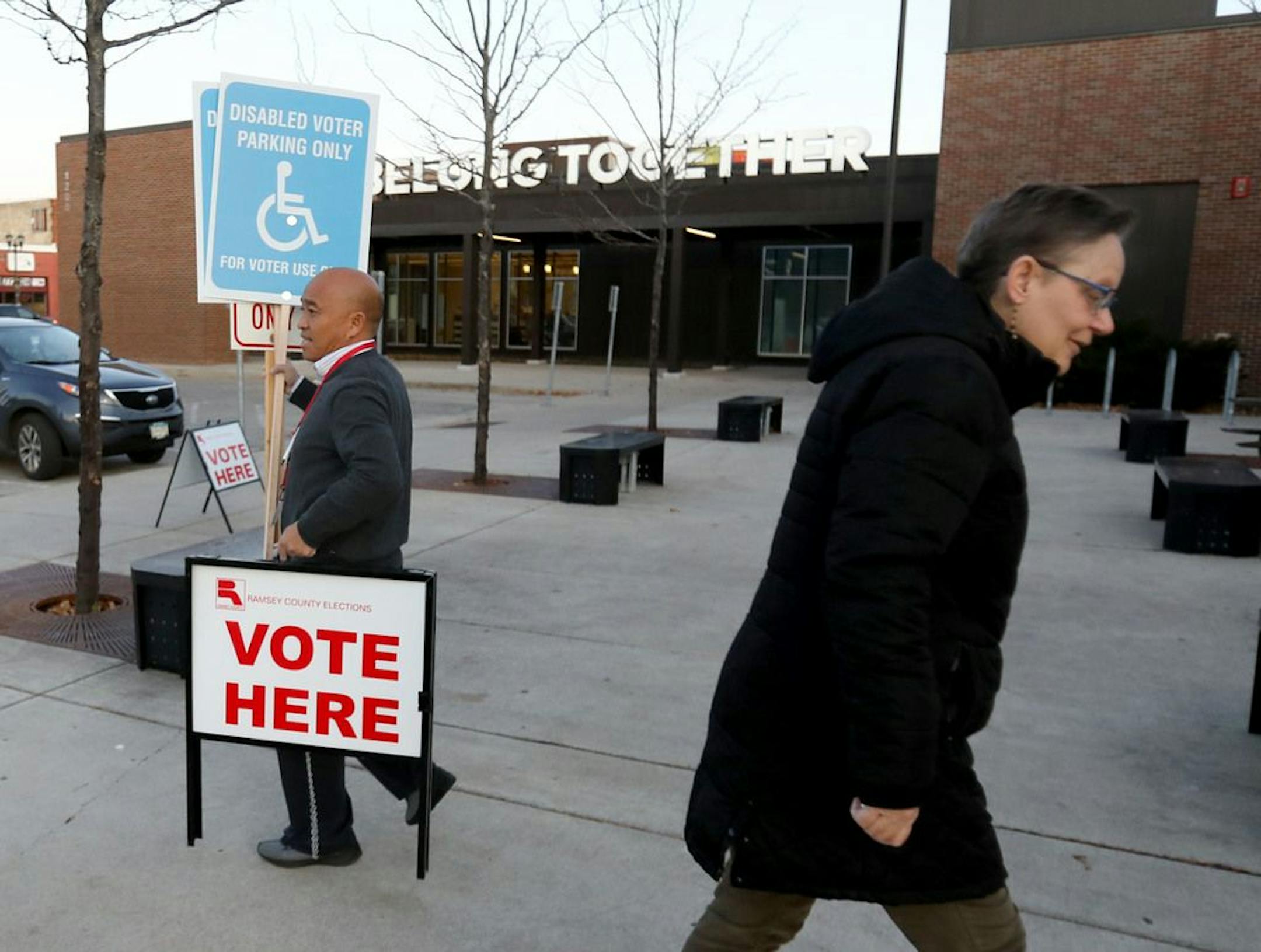 Election judge Chris Yang carried voting signs to the parking lot at the start of polling Tuesday, Nov. 5 2019, at the Arlington Hills Community Center in St. Paul, MN.