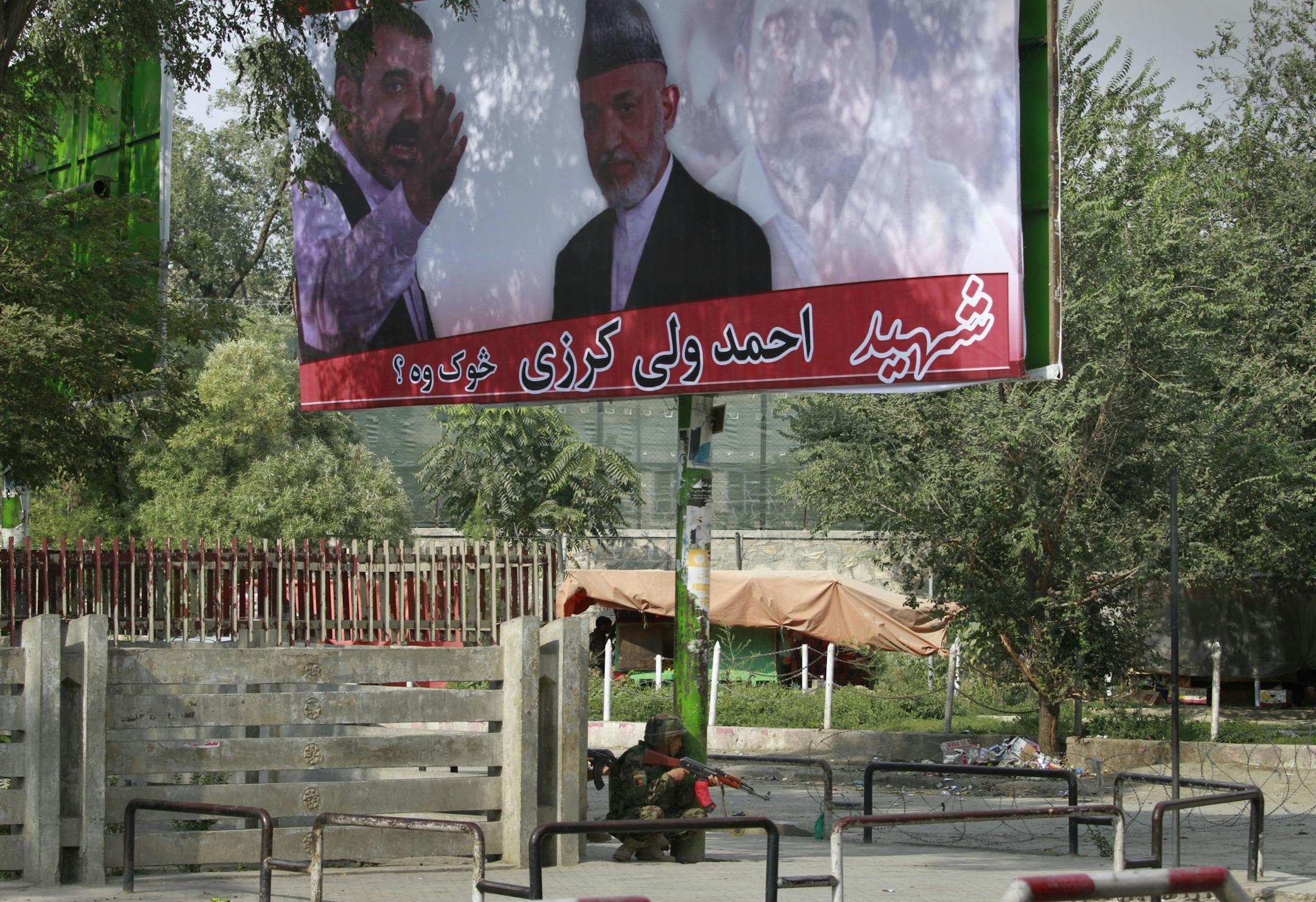 An Afghan soldier takes position under a huge poster of Afghan President Hamid Karzai with his late brother Ahmad Wali Karzai, during a gun battle with militants in Kabul, Afghanistan on Tuesday, Sept. 13, 2011. Taliban insurgents fired rocket-propelled grenades and assault rifles at the U.S. Embassy, NATO headquarters and other buildings in the heart of the Afghan capital Tuesday in a brazen attack two days after the United States marked the 10th anniversary of the Sept. 11 terror attacks.