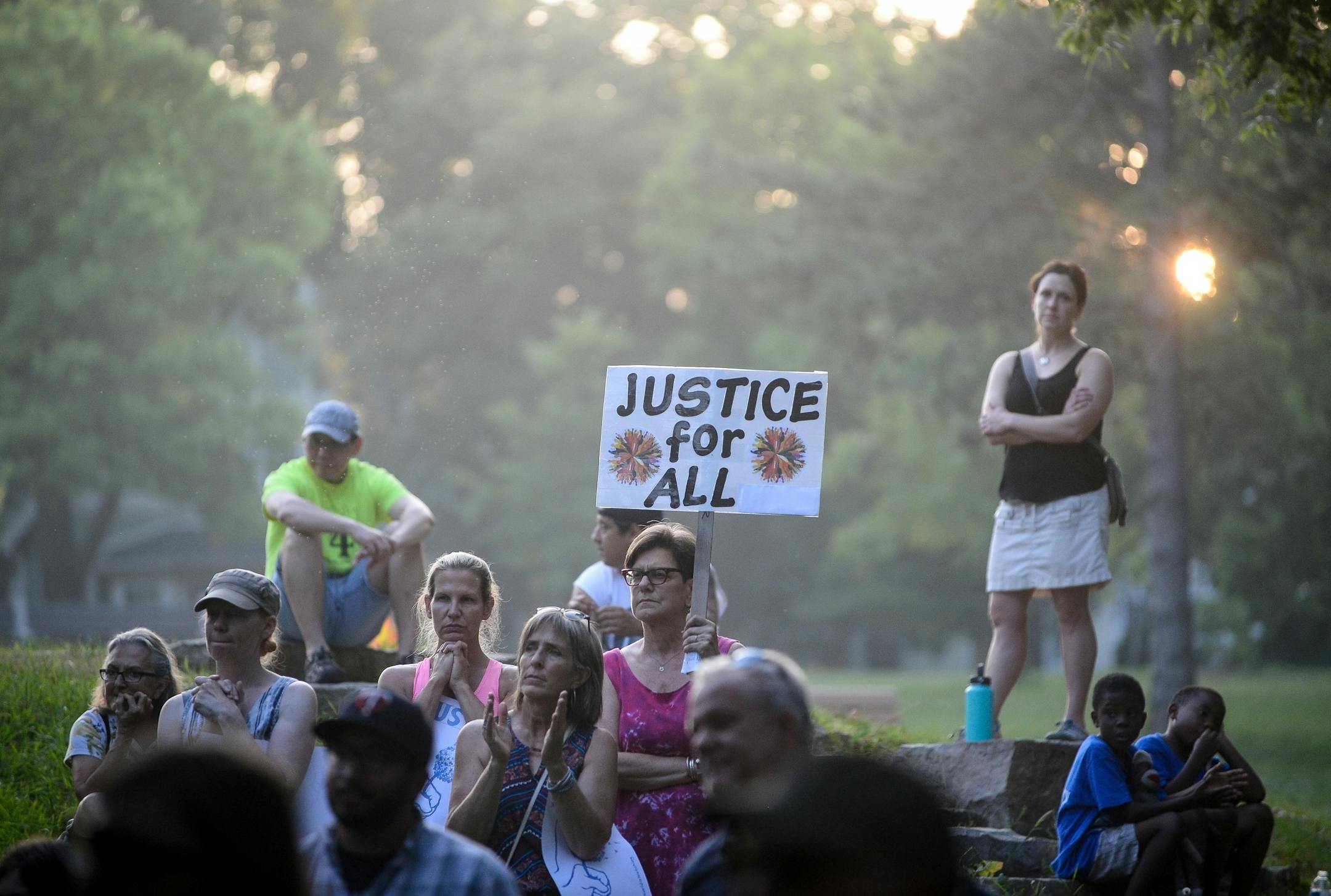 The sun set behind demonstrators at Beard's Plaissance Park Thursday night.