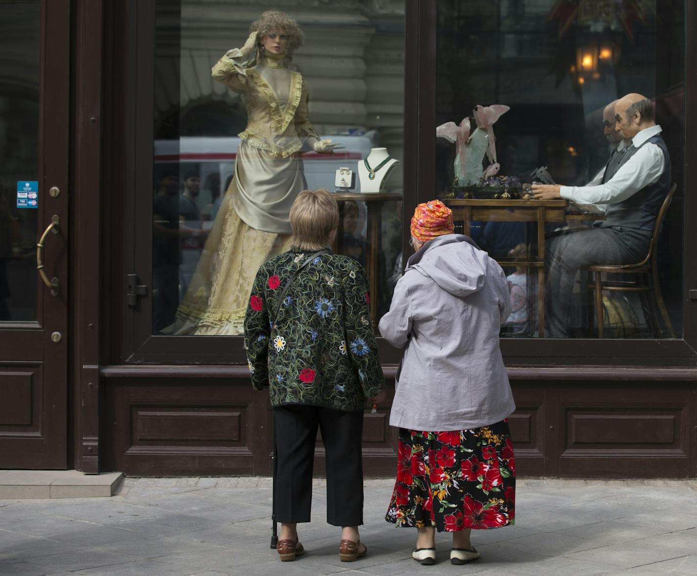 Two elderly women look at a shop show case near Red Square in Moscow, Russia, Saturday, Sept. 6, 2014. Celebrations marking the Day of Moscow were held in Red Square on Saturday. (AP Photo/Alexander Zemlianichenko)