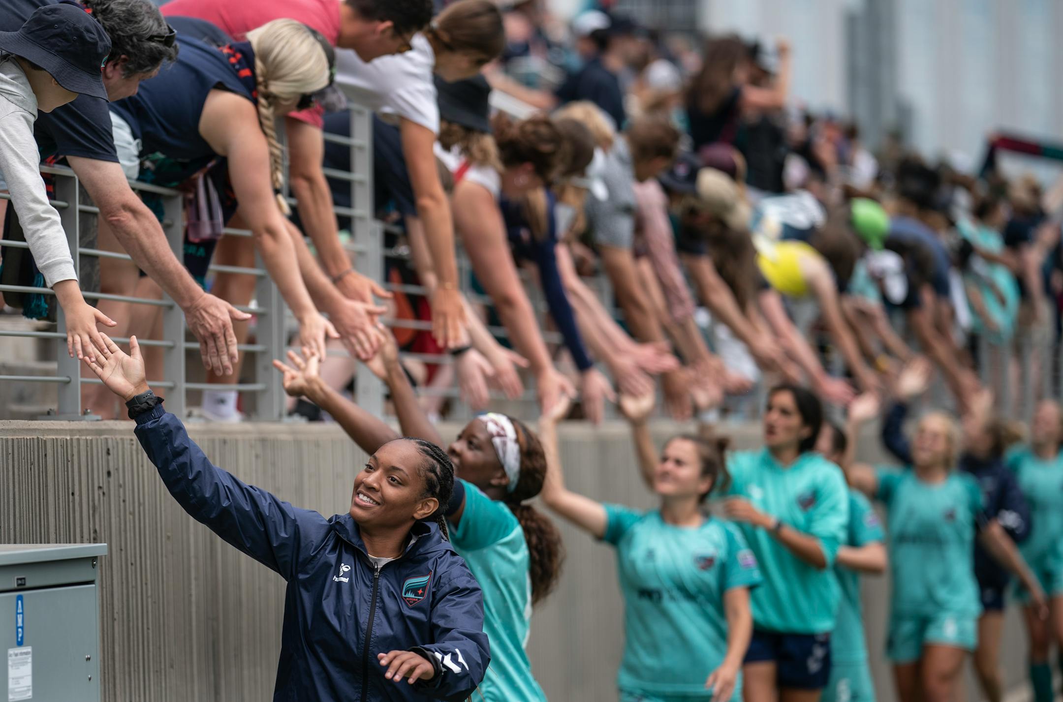 The Minnesota Aurora team celebrates with fans after the game.