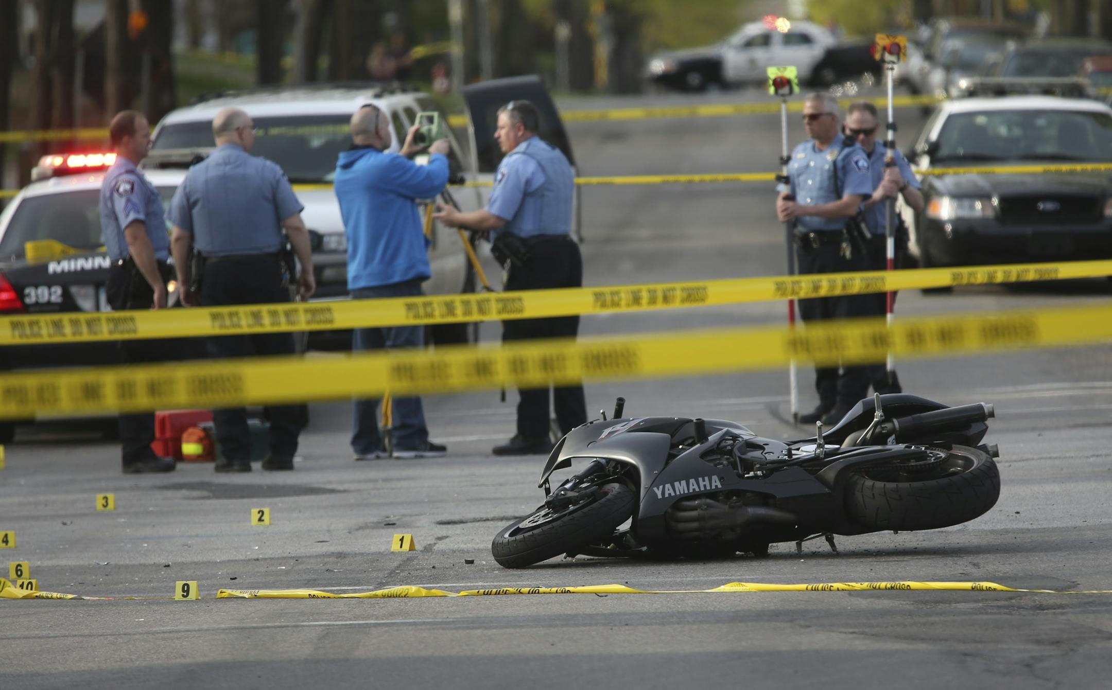 Minneapolis police officers surveyed the scene where a police vehicle and motorcycle collided at the intersection of Blaisdell and 26th in Minneapolis, Min., Friday, May 10, 2013.