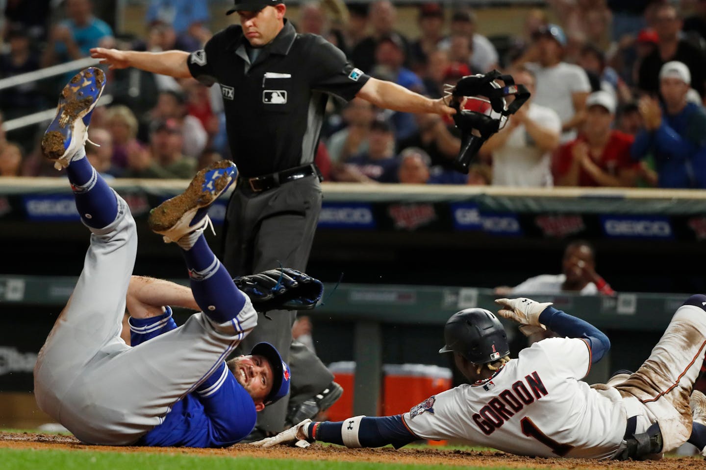 Nick Gordon scores past Toronto relief pitcher Tim Mayza on a squeeze play in the sixth inning Saturday. Mayza was hurt on the play and left the game.