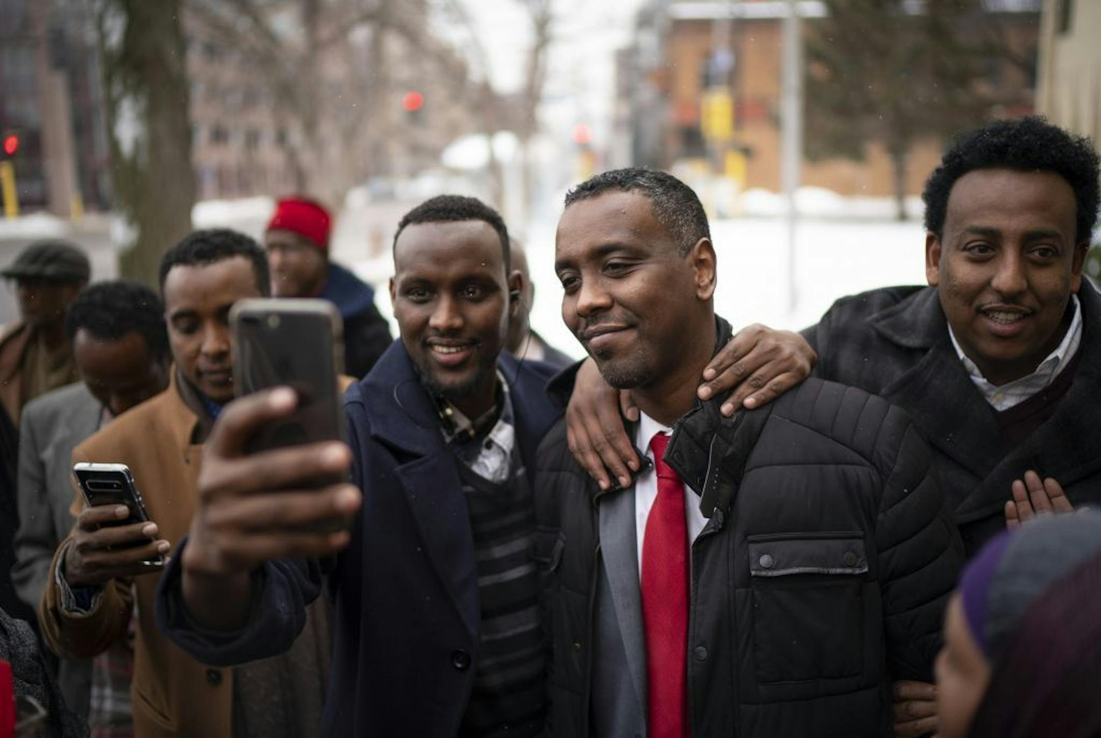 Minneapolis Council Member Abdi Warsame, second from right, was surrounded by supporters wanting celebratory selfies with him after he was hired as the next executive director of the Minneapolis Public Housing Authority Wednesday afternoon. They were outside the MPHA offices on Washington Ave. N. in Minneapolis.