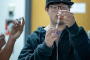 Washington Technology Magnet School senior Jorge Vargas learns how to administer an injectable naloxone during his class in St. Paul, Minn., on Thursd