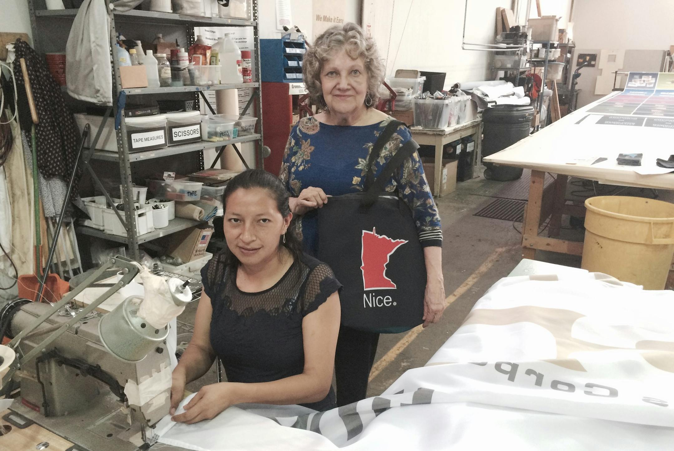 Gladys Zhagui, seated, and Nora Norby, president of Banner Creations, in the company’s northeast Minneapolis workroom.