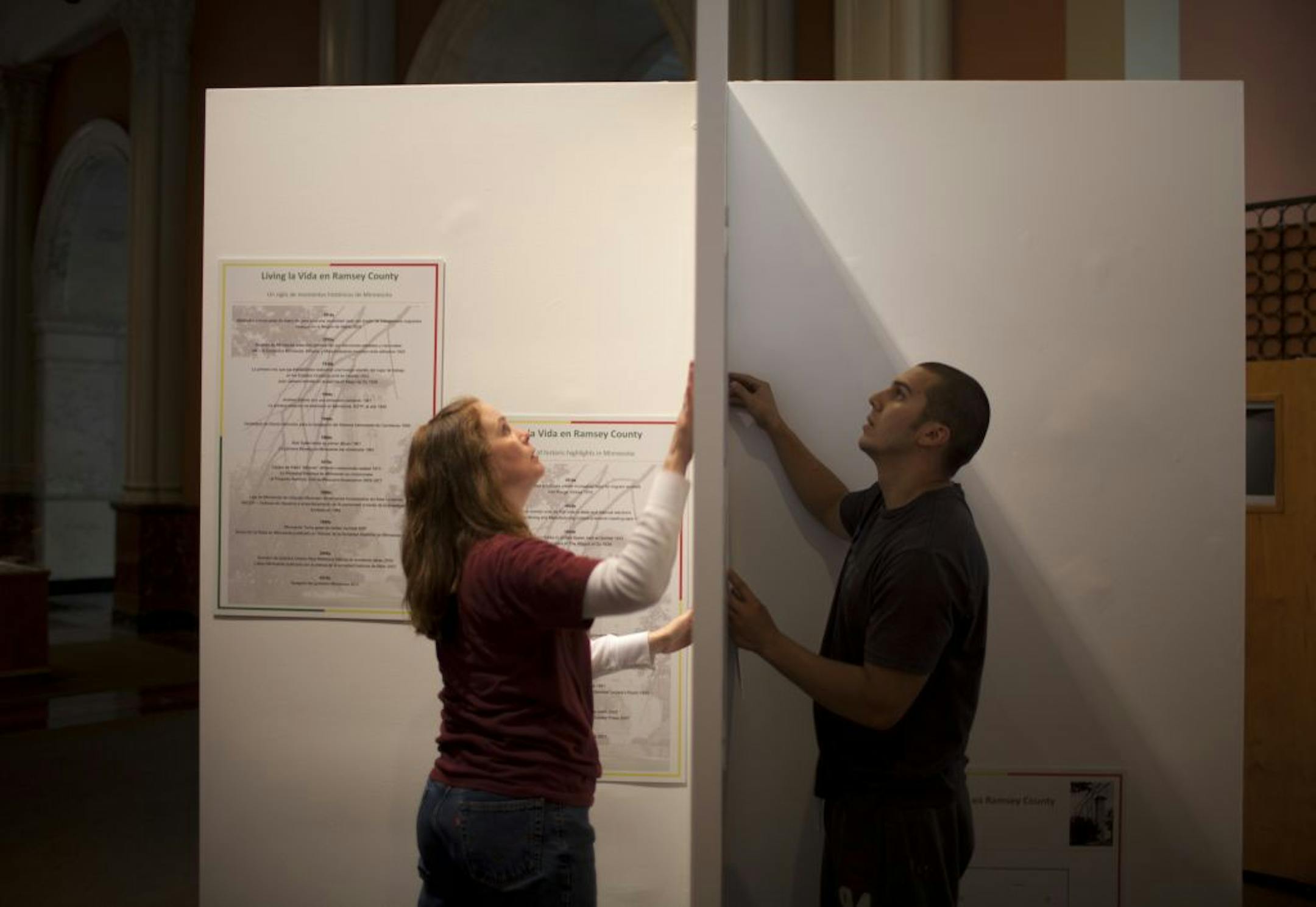 Historian and guest curator Leila Albert, left, and Jose Anaya installed placards that are a part of the "Living la Vida in Ramsey County" exhibit opening Thursday in downtown St. Paul's Landmark Center.