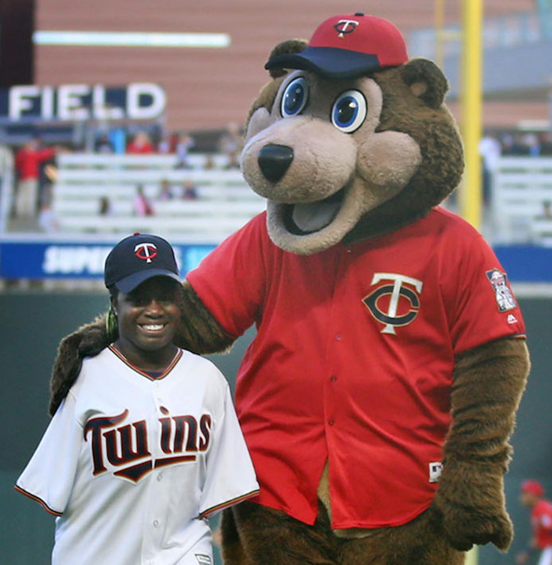 Anna Younker-Zimmerman, a St. Paul student who was born without arms, walks off the pitcher's mound with TC Bear after throwing out the first pitch at the Minnesota Twins and Baltimore Orioles game at Target Field Friday, April 26, 2019, in Minneapolis, MN.] DAVID JOLES •david.joles@startribune.com Anna Younker-Zimmerman was born without arms, but that did not stop her from competing athletically, even when it came to bowling and playing softball. A year ago, she graduated from St. Paul's