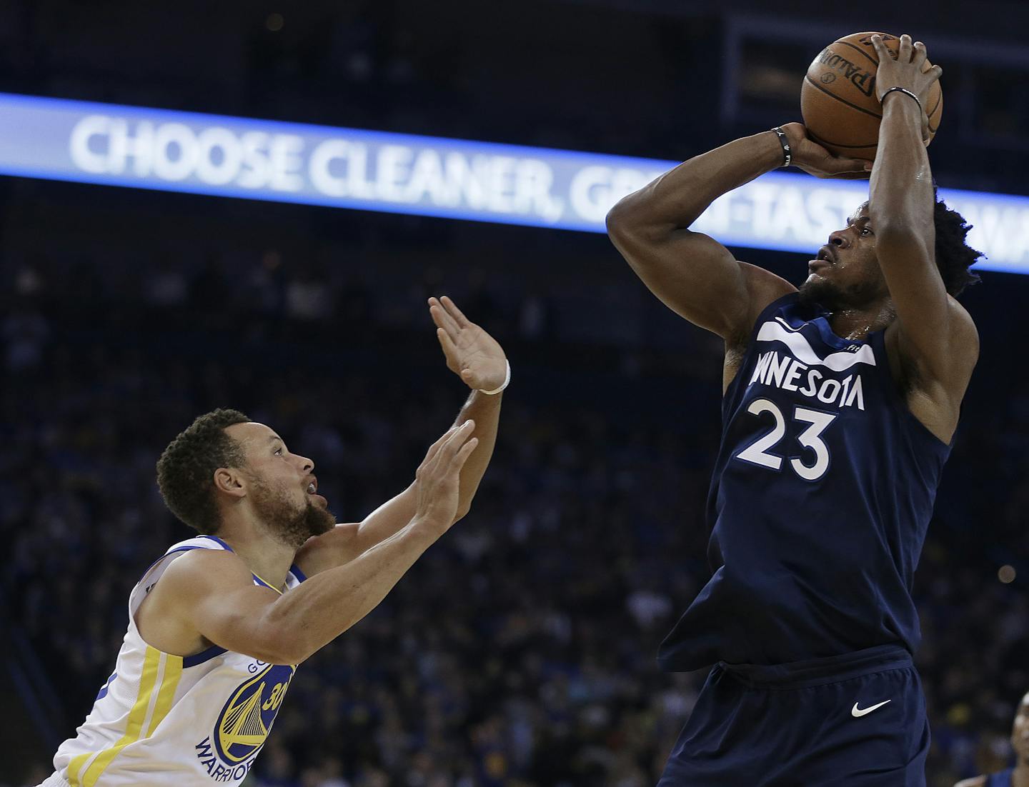 Minnesota Timberwolves' Jimmy Butler (23) shoots against Golden State Warriors' Stephen Curry during the first half of an NBA basketball game Wednesday, Nov. 8, 2017, in Oakland, Calif. (AP Photo/Ben Margot)