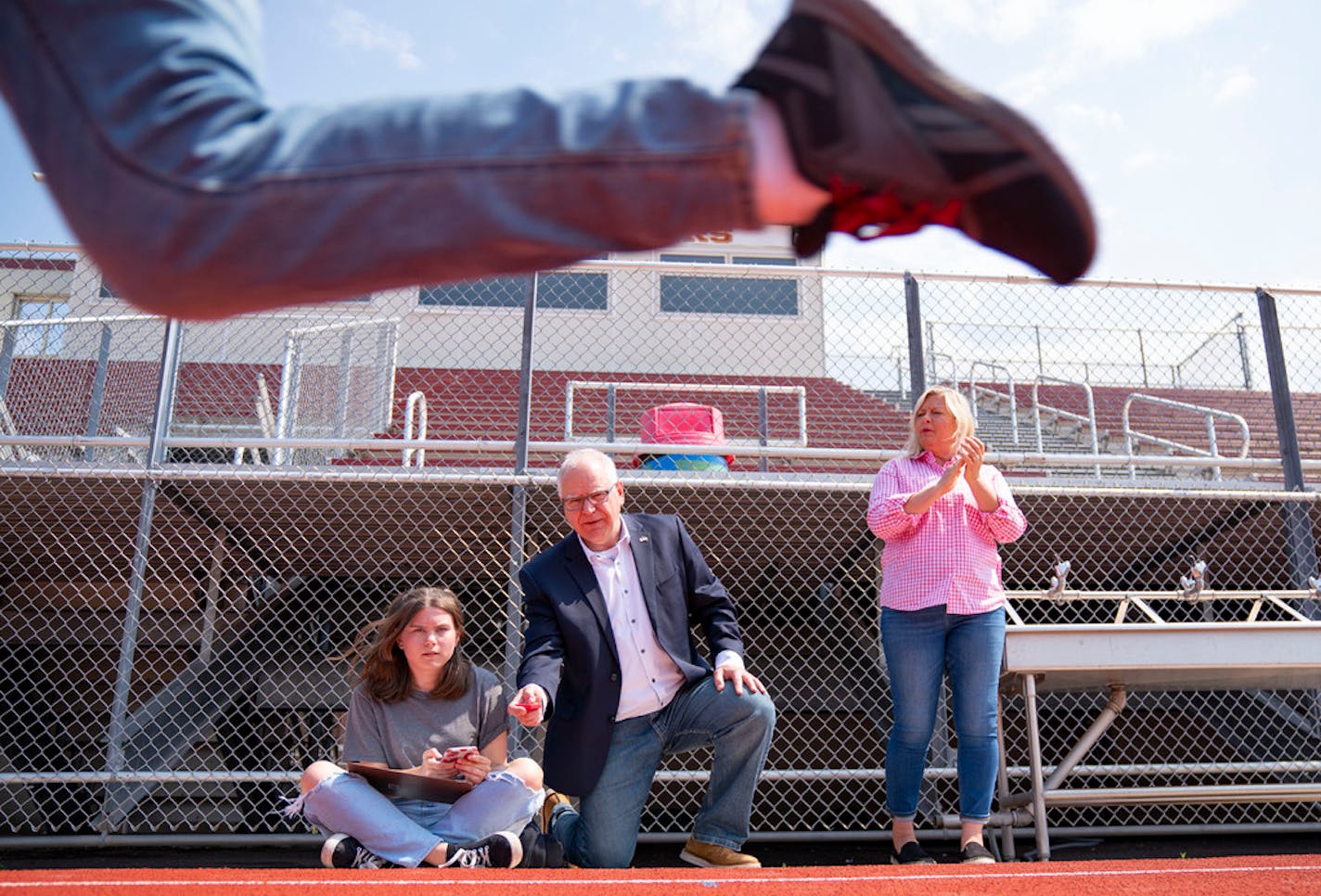 (From Left) Lilly Aleshire, a rising sophomore at Denfeld High School and Governor Tim Walz timed students during a physical science acceleration lab to calculate average speed as they ran on the track at Denfeld. Education Commissioner Heather Mueller also watched the lab unfold at Denfeld High School in Duluth as part of the Walz and Lt. Gov. Peggy Flanagan's statewide education tour on Tuesday, July 13, 2021.