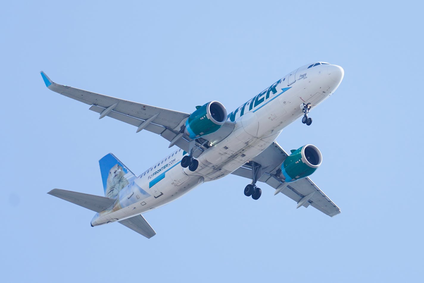 Frontier Airlines plane in sky.