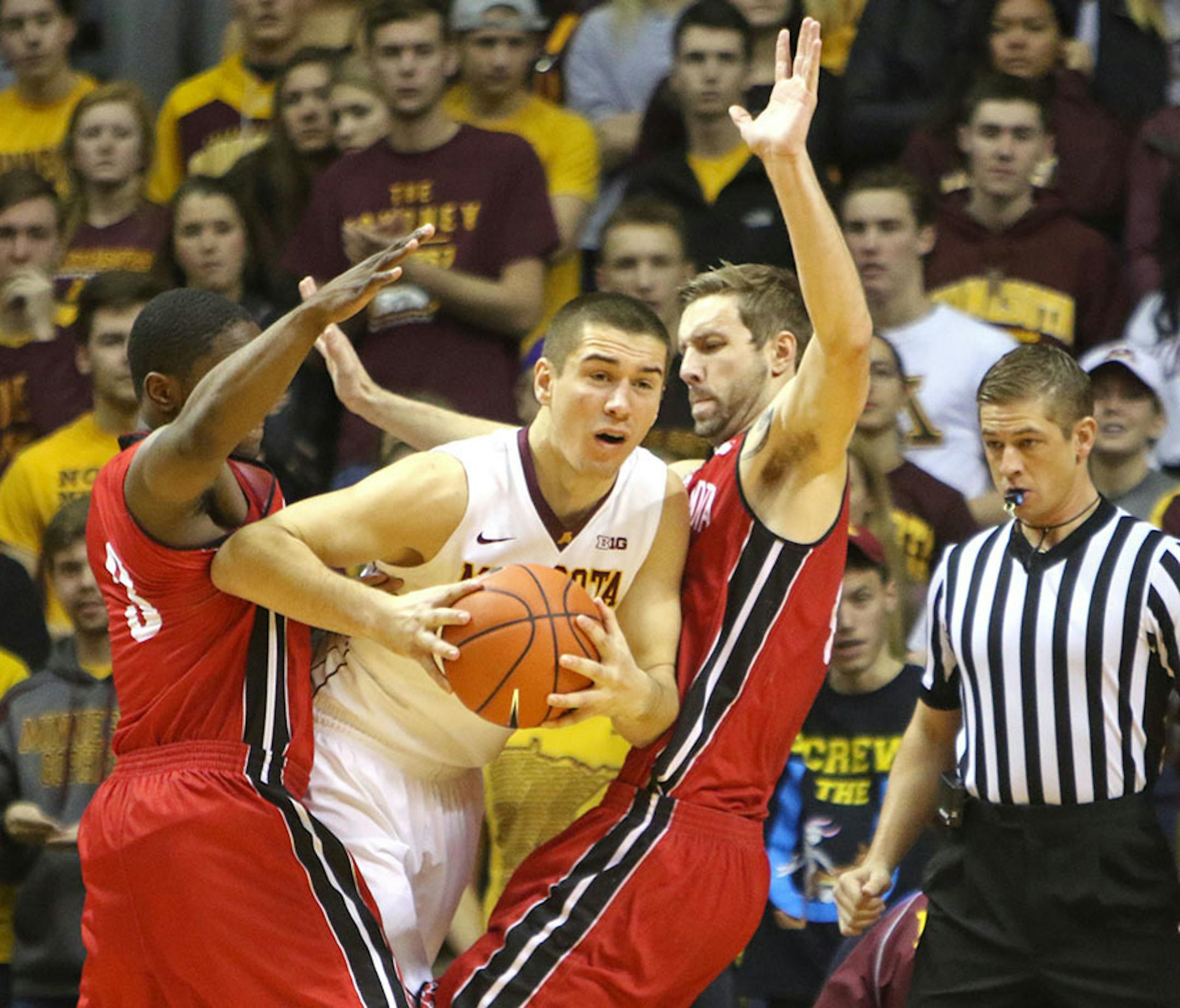 Gophers forward Joey King was sandwiched between South Dakota's Shy McClelland (3) and Eric Robertson, right, during the first half of their 85-81 double overtime loss to South Dakota at Williams Arena on Saturday.